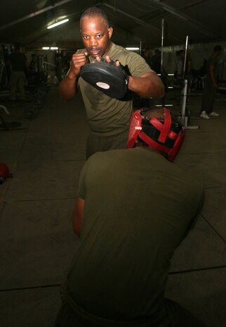 Teaching a student to dodge blows, Master Sgt. Michael L. Stephens, communications chief for 2nd Light Armored Reconnaissance Battalion, Regimental Combat Team 5, trains Marines within the battalion the fundamentals of boxing at Camp Korean Village, Iraq, April 21. After 28 years of service in three different military branches, Stephens is on his second combat tour in Iraq and loves training Marines how to fight.