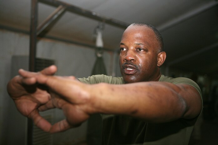Stretching his upper back, Master Sgt. Michael L. Stephens, 47, communications chief for 2nd Light Armored Reconnaissance Battalion, Regimental Combat Team 5 trains Marines the fundamentals of boxing at Camp Korean Village, Iraq, April 21. The Miami native has served close to 30 years in the military with three different branches.