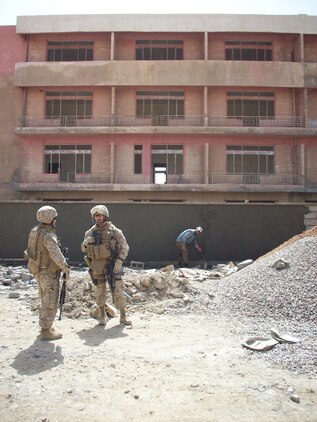 Lt. Timothy J. Rajcevich, civil affairs team leader, and Staff Sgt. Richard A. Gonzales,  civil affairs team chief, both with Detachment 1, Civil Affairs Team 3, 2nd Battalion, 11th Marine Regiment, Regimental Combat Team 5, survey the progress made on the new teachers institute in Hit, Iraq, April 13. By providing Hit with a facility to train teachers, the town will have trained teachers to educate the children.