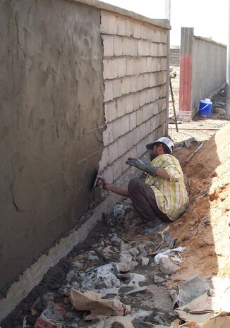 A worker hired by a local contractor works on the wall that will surround the newly refurbished teachers institute, in Hit, Iraq, April 13. The institute is expected to be completed in June and will be capable of training 300 elementary level teachers at any given time.   The building was previously used as a military outpost by Coalition forces.