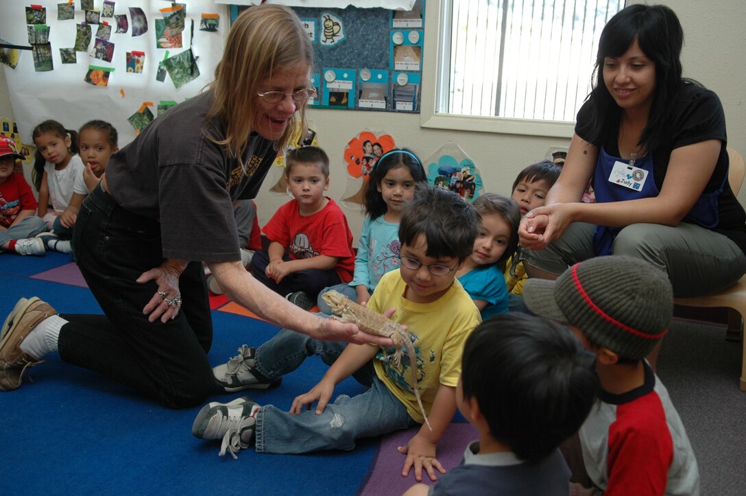 Sue Miller introduces children to a lizard during the annual “Cruzzin’ Critters” presentation at the depot Child Development Center April 21, as part of Earth Day 2008. The program features a hands-on collection of furry creatures and reptiles.