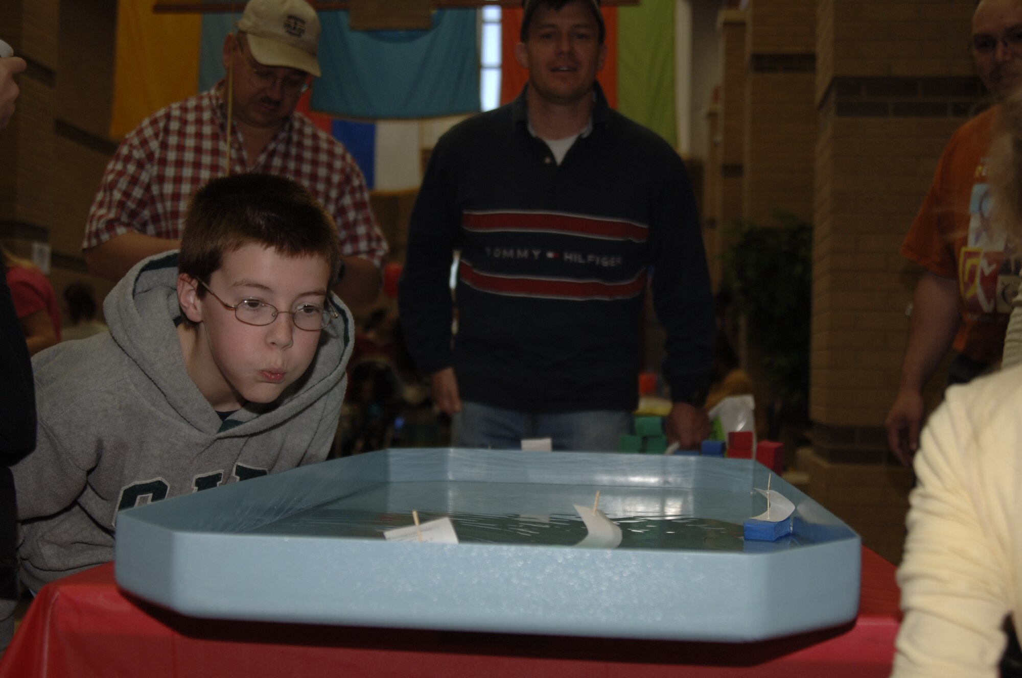 MCCONNELL AIR FORCE BASE, Kan. -- Tim Cargle, a Team McConnell family member, blows air on the sail of a foam boat during a racing game offered at the 10th annual Family Festival of Fun at the Robert J. Dole Center, April 19.  Games like the foam boat race were one of the many forms of entertainment offered to children at the festival.  (Photo by Staff Sgt. Ronald Lafosse)