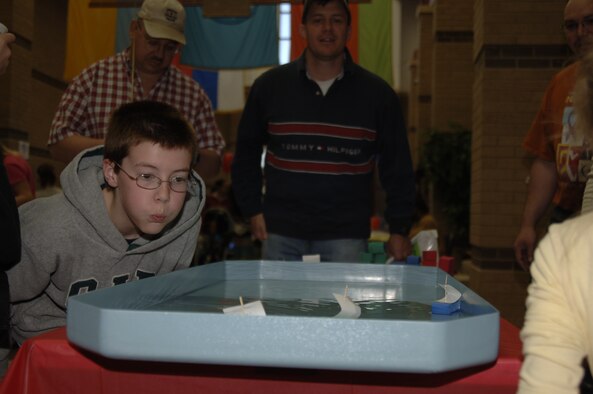 MCCONNELL AIR FORCE BASE, Kan. -- Tim Cargle, a Team McConnell family member, blows air on the sail of a foam boat during a racing game offered at the 10th annual Family Festival of Fun at the Robert J. Dole Center, April 19.  Games like the foam boat race were one of the many forms of entertainment offered to children at the festival.  (Photo by Staff Sgt. Ronald Lafosse)