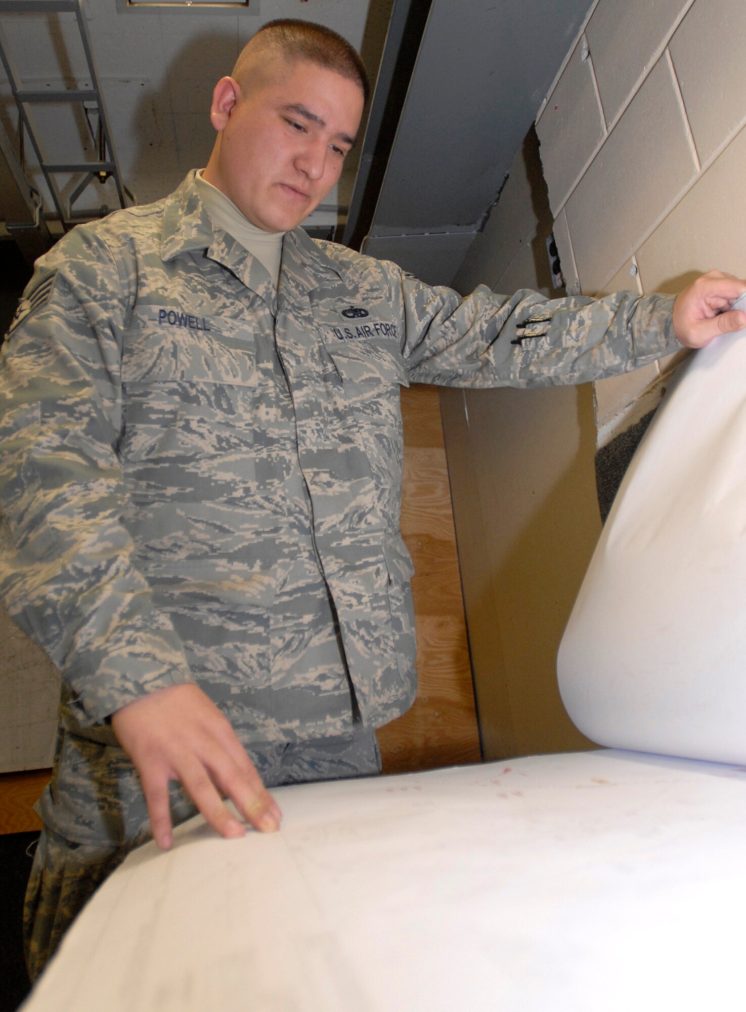 KUNSAN AIR BASE, Republic of Korea— Staff Sergeant Jon Powell, 8th Communications Squadron NCO in charge of visual imagery and intrusion detection systems and wideband maintenance, goes over plans April April 15 here. (U.S. Air Force Photo/Senior Airman Dana Hill) 