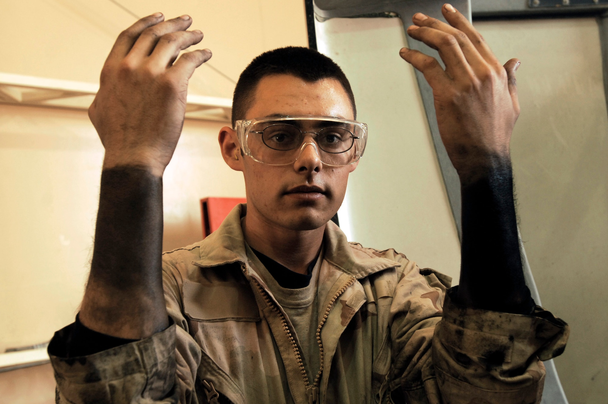 Senior Airman Ryan Duncan shows the grease marks on his arms from working on M915A3 tractor-trailer trucks during scheduled maintenance recently at an Army camp in Southwest Asia. The Airmen of the 70th and 424th MTDs assigned to the 586th ELRS are in-lieu-of forces supporting the Army support line-haul convoy movements in and out of Iraq. Airman Duncan is a vehicle maintainer deployed to the 586th Expeditionary Logistics Readiness Squadron, 70th Medium Truck Detachment. (U.S. Air Force photo/Staff Sgt. Patrick Dixon)