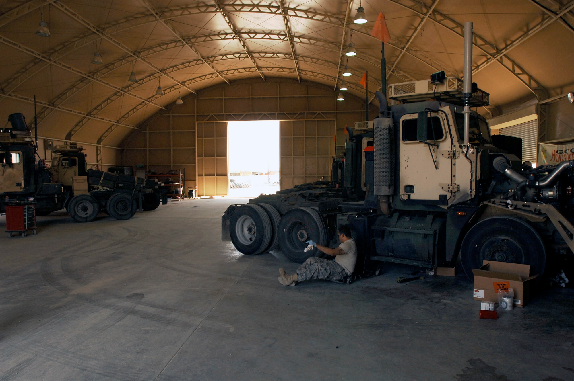 Senior Airman Lesther Lopez prepares to slide up under a M915A3 tractor-trailer truck during scheduled maintenance recently at an Army camp in Southwest Asia. The Airmen of the 70th and 424th MTDs assigned to the 586th ELRS are in-lieu-of forces supporting the Army support line-haul convoy movements in and out of Iraq. Airman Lopez is a vehicle maintainer deployed to the 586th Expeditionary Logistics Readiness Squadron, 70th Medium Truck Detachment. (U.S. Air Force photo/Staff Sgt. Patrick Dixon) 