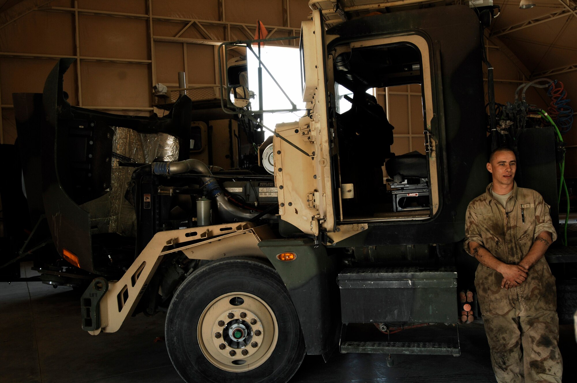 Staff Sgt. Tibor Pecsuk takes a quick break during scheduled maintenance on a M915A3 tractor-trailer truck recently at an Army camp in Southwest Asia. The Airmen of the 70th and 424th MTDs assigned to the 586th ELRS are in-lieu-of forces supporting the Army support line-haul convoy movements in and out of Iraq. Sergeant Pecsuk is a vehicle maintainer deployed to the 586th Expeditionary Logistics Readiness Squadron, 70th Medium Truck Detachment. (U.S. Air Force photo/Staff Sgt. Patrick Dixon) 