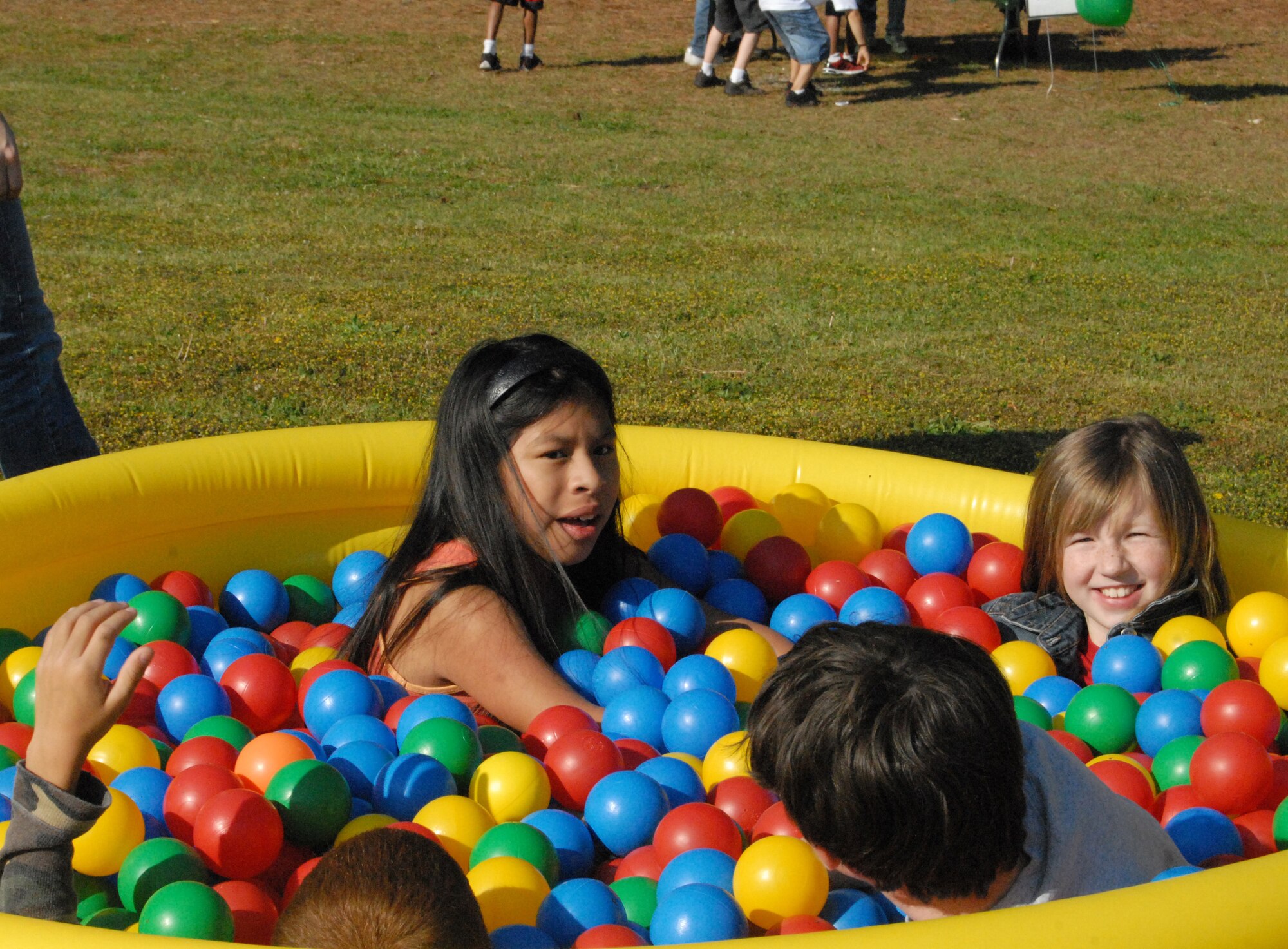 Cierra Knight, 10, and her friends celebrate Earth Day in a colorful pool of rubber balls. Children at Pope Elementary went through different sections of fun, to include; blowing bubbles with Sparky, jumping in a bouncy castle and riding ponies. (U.S. Air Force Photo by Staff Sgt. Cassandra Locke)
