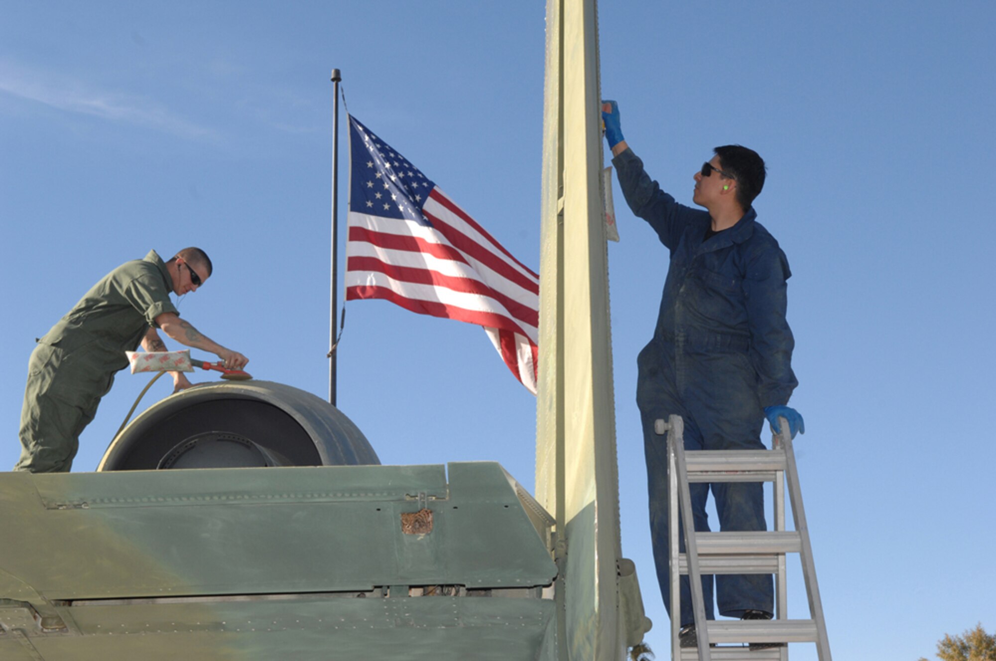 Airmen First Class David Lopez, right, and Kevin Hetzler, both 355th Equipment Maintenance Squadron sheet metal journeymen, sand down an old A-10 at Heritage Park Jan. 25. All nine planes at the park will receive restoration over the next few months to get ready for the 355th Fighter Association 65th Annual Reunion April 24 to 27. (U.S. Air Force photo by Senior Airman Alesia D. Goosic)
