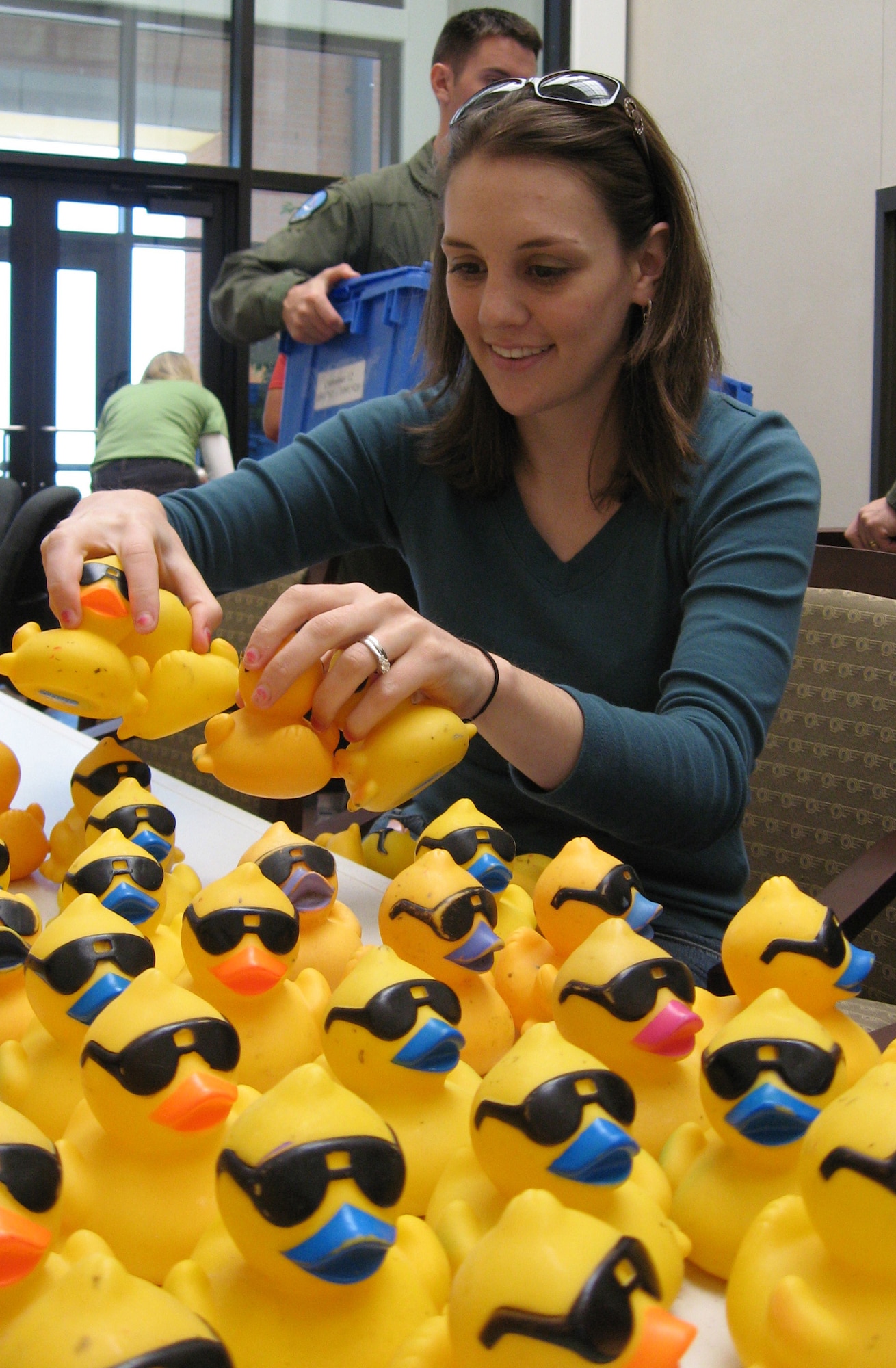 Sara Tuchscher, wife of 80th Operations Support Squadron 2nd Lt. Matthew Tuchscher, gets her ducks in a row April 18 after placing numbers on them in preparation for the 2nd Annual Children's Miracle Network Rubber Duck River Derby in May. OSS personnel and family members and CMN representatives numbered about 10,000 ducks in preparation for the race. (U.S. Air Force photo/Mike McKito)
