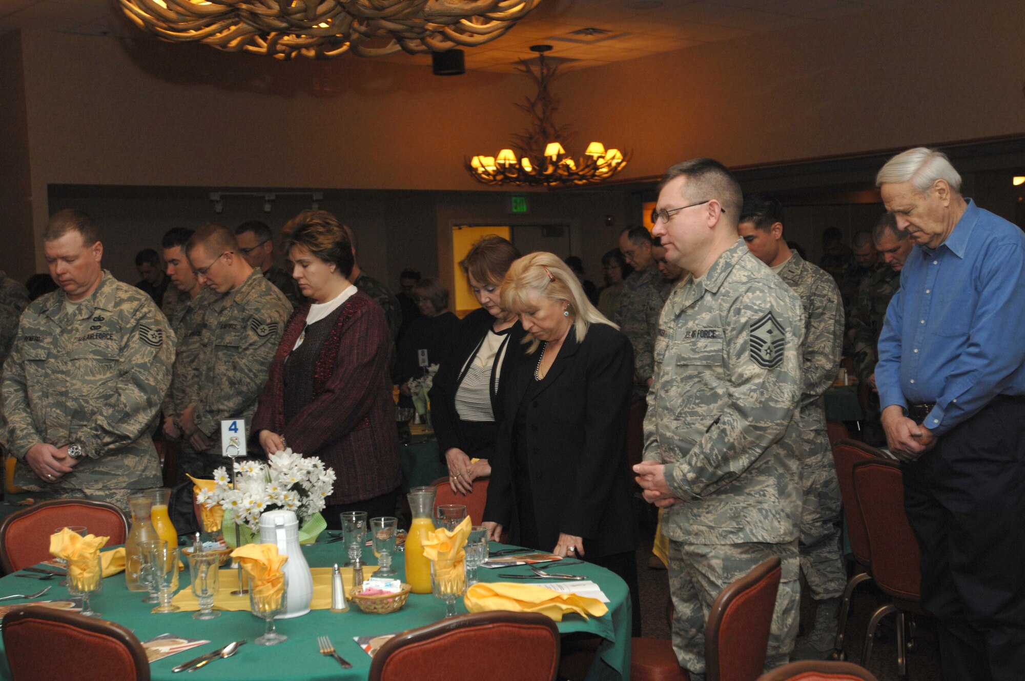 Airmen and family members bow their heads in prayer during the National Prayer Breakfast, Eielson Air Force Base, Alaska, April 16, 2008.  (U.S. Air Force photo/Staff Sgt. Tia Schroeder)