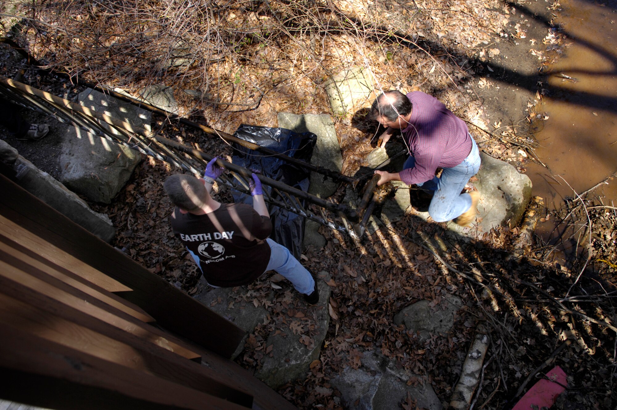 HANSCOM AFB, Mass. - Volunteers lift a discarded bicycle rack out of the Shawsheen River behind the primary and middle schools.  The river area was the site for the annual Earth Day Shawsheen River Cleanup, held April 18. (U.S. Air Force photo by Mark Wyatt)