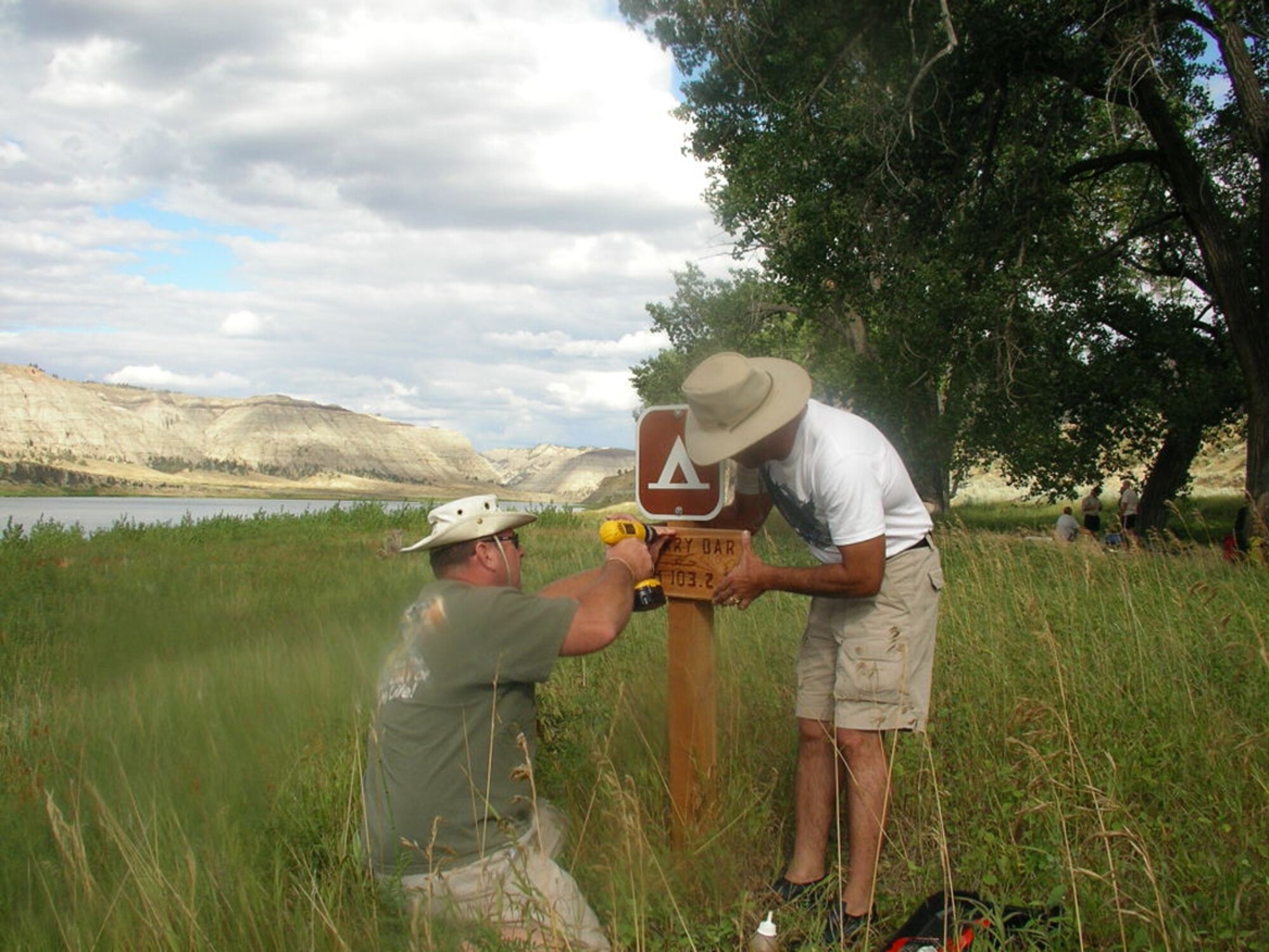 Chief Master Sgt. Larry Wilson (left) and Col. Steve Asher (right) work together to place a campsite marker along the Missouri River while serving as voluntary river patrols for the Bureau of Land Management. The two Security Forces Group leaders organized a volunteer force of their Airmen to assist the BLM with several large projects during 2007. (Courtesy photo)