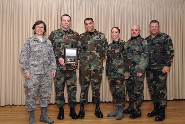 The Professional Team of the Quarter pictured here with 341st Space Wing Commander Col. Sandy Finan, left, and 341st Space Wing Command Chief Chief Master Sgt. Steve Sargent, right, are: Staff Sgt. Joshua Hauser, Staff Sgt. Brian Geike, Tech. Sgt. Lisa Bradley, and Master Sgt. Stephen Flack. The four are members of the Security Forces Training Section. (U.S. Air Force photo/John Turner)