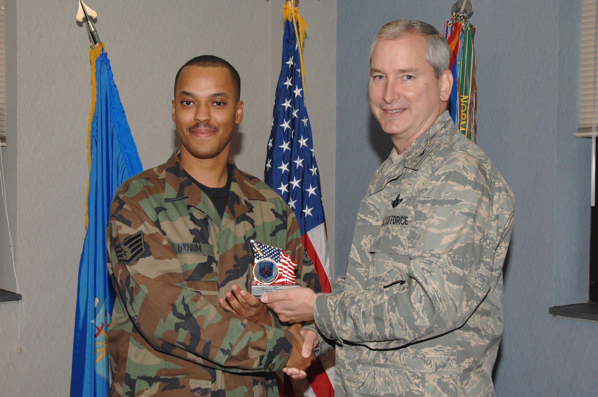 SEYMOUR JOHNSON AIR FORCE BASE, N.C. -- Staff Sgt. Samaad Bynum (right) receives the Air Force Reserve Command Historical Services Wing History Award for 2007 from 916th Air Refueling Wing Commander, Col. Fritz Linsenmeyer. Sergeant Bynum wrote the first electronic history for the 916th setting the benchmark for other wings to follow. "Receiving the AFRC historian award is a great accomplishment," said Sgt. Bynum. "It shows that the 916th is participating in historical events that are worth remembering."  U.S. Air Force photo/TSgt. Gillian Albro