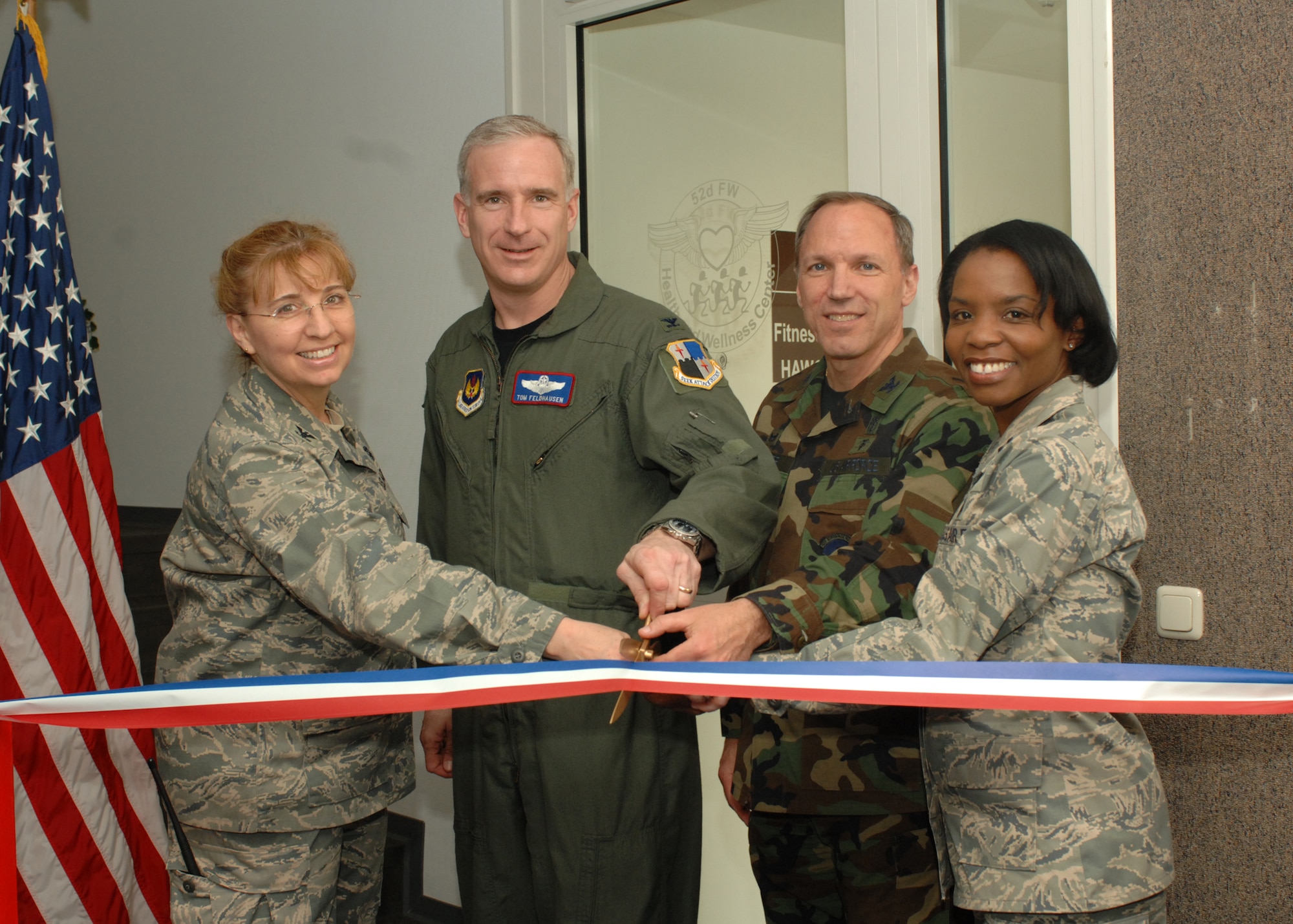 SPANGDAHLEM AIR BASE, Germany -- (Left to Right) Col. Lorrie Cappellino, 52nd Medical Group commander, Col. Thomas Feldhausen, 52nd Fighter Wing commander, Col. Parker Plante, 52nd Aerospace Medicine Squadron commander, and Capt. Sarah Evans, 52nd AMDS, wait one final moment before cutting the ribbon to the newly renovated Health and Wellness Center now located in the Skelton Fitness Center April 21, 2008. (U.S. Air Force photo/Airman 1st Class Jenifer Calhoun)
