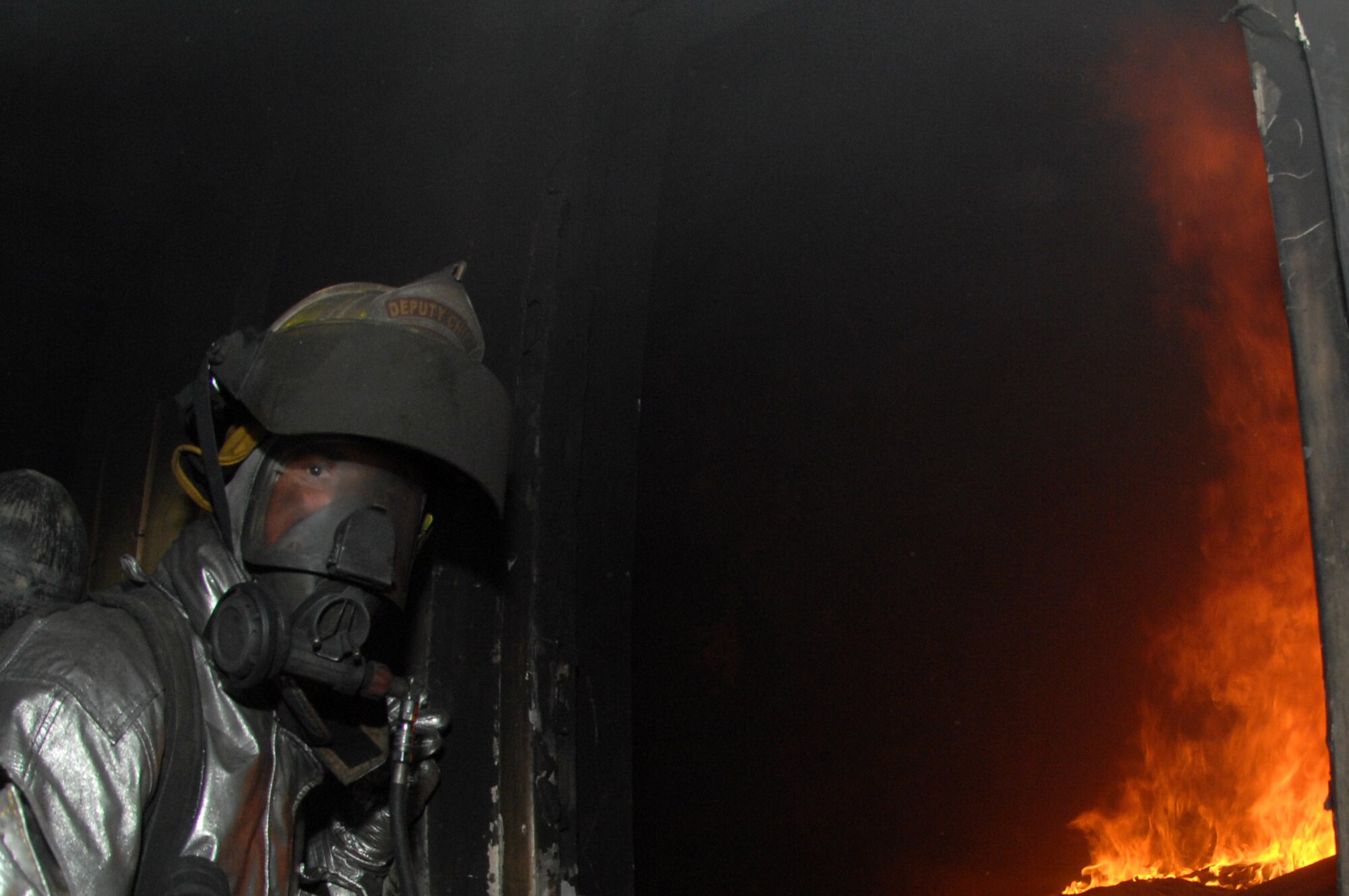 KIRKUK REGIONAL AIR BASE, Iraq -- Senior Master Sgt. Dana Walton, 506th Expeditionary Civil Engineer Squadron deputy fire chief, leads the way into a burning bunker during live fire training with Iraqi air force firefighters here recently. Sergeant Walton is deployed here from McGuire Air Force Base, N.J. (U.S. Air Force photo by Senior Master Sergeant Don Senger)