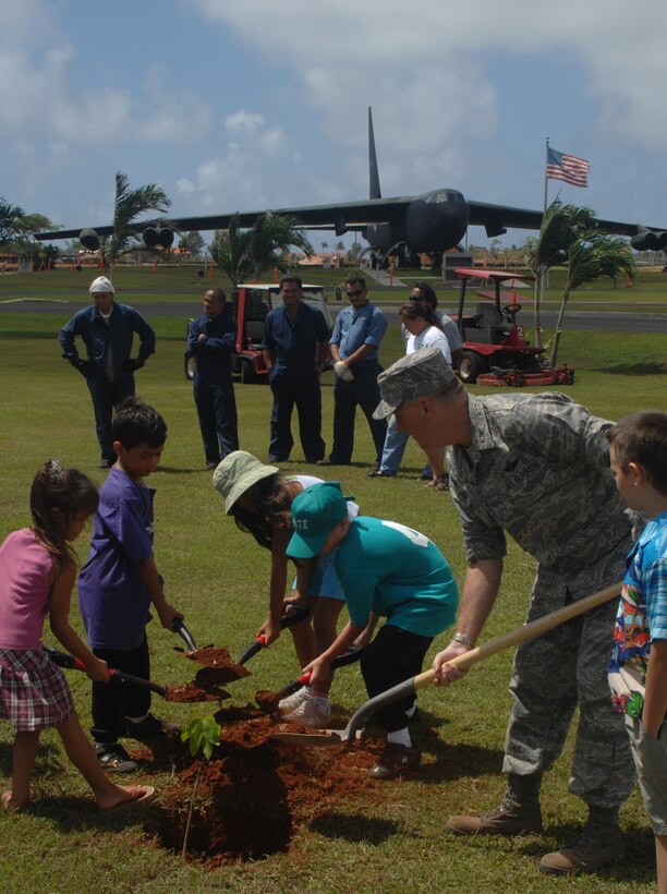 Col. Gregory Cain, 36th Wing vice commander, digs a hole to plant an Ifit tree with the help of several junior Team Andersen members during Andersen's Earth Day April 19 here. (U.S. photo by Airman 1st Class Zachary Hunter)
