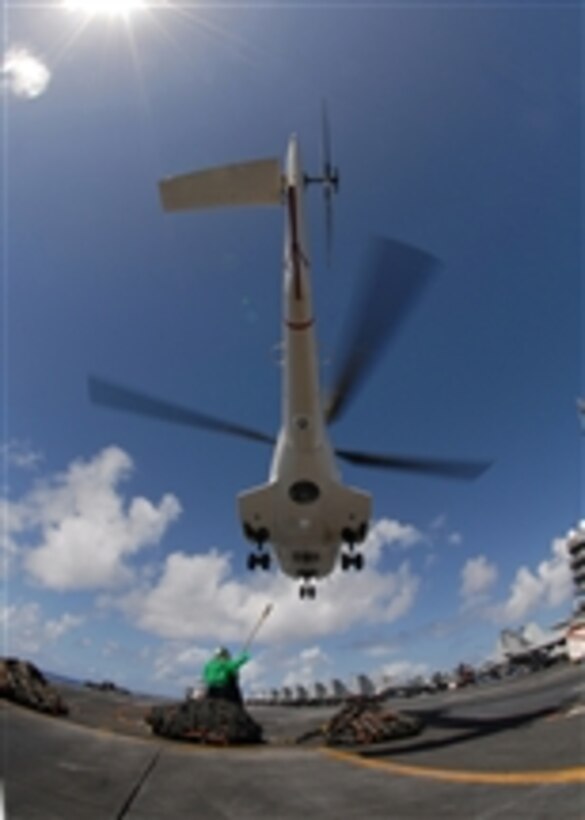 U.S. Navy sailors attach bundles of cargo netting to an AS-332 Super Puma helicopter on the flight deck of the Nimitz-class aircraft carrier USS Abraham Lincoln (CVN 72) during a vertical replenishment with combat stores ship USNS Niagara Falls (T-AFS 3) while underway in the Pacific Ocean on April 5, 2008.  