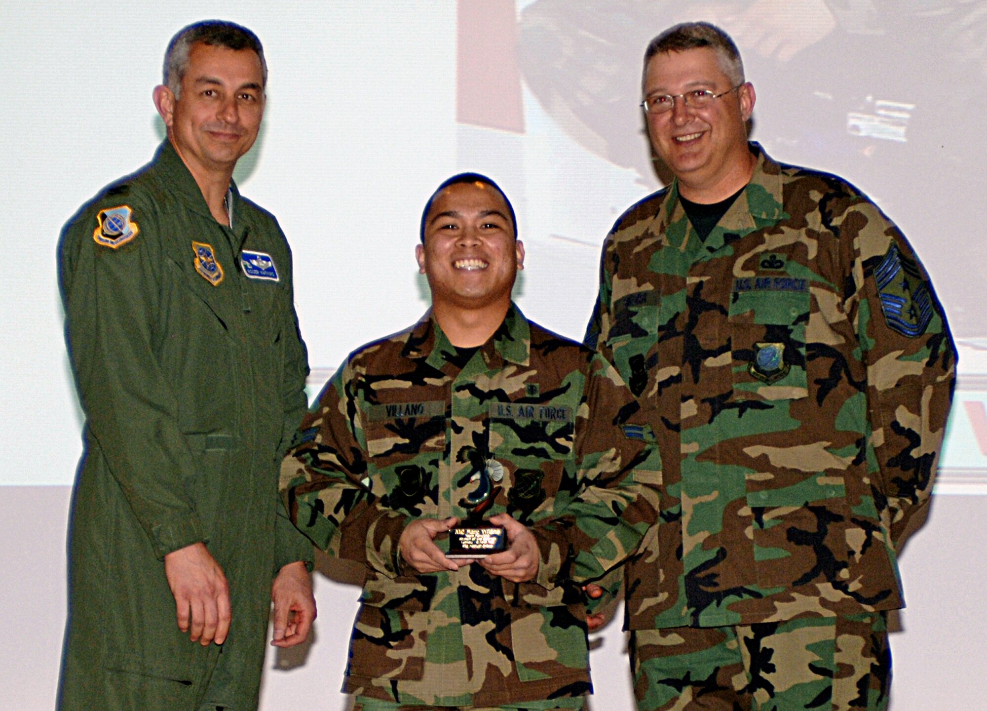 FAIRCHILD AIR FORCE BASE, Wash. – Col. Roger Watkins, 92nd Air Refueling Wing acting commander, and 92nd ARW Command Chief Master Sgt. Paul Sikora, present Airman 1st Class Mark Villano, 92nd Medical Group, with the 92nd ARW Airman of the Quarter award at the base theater April 22. Airman Villano also won the Team Fairchild award for superior performance.(U.S. Air Force photo / Airman 1st Class Melissa Barnett) 