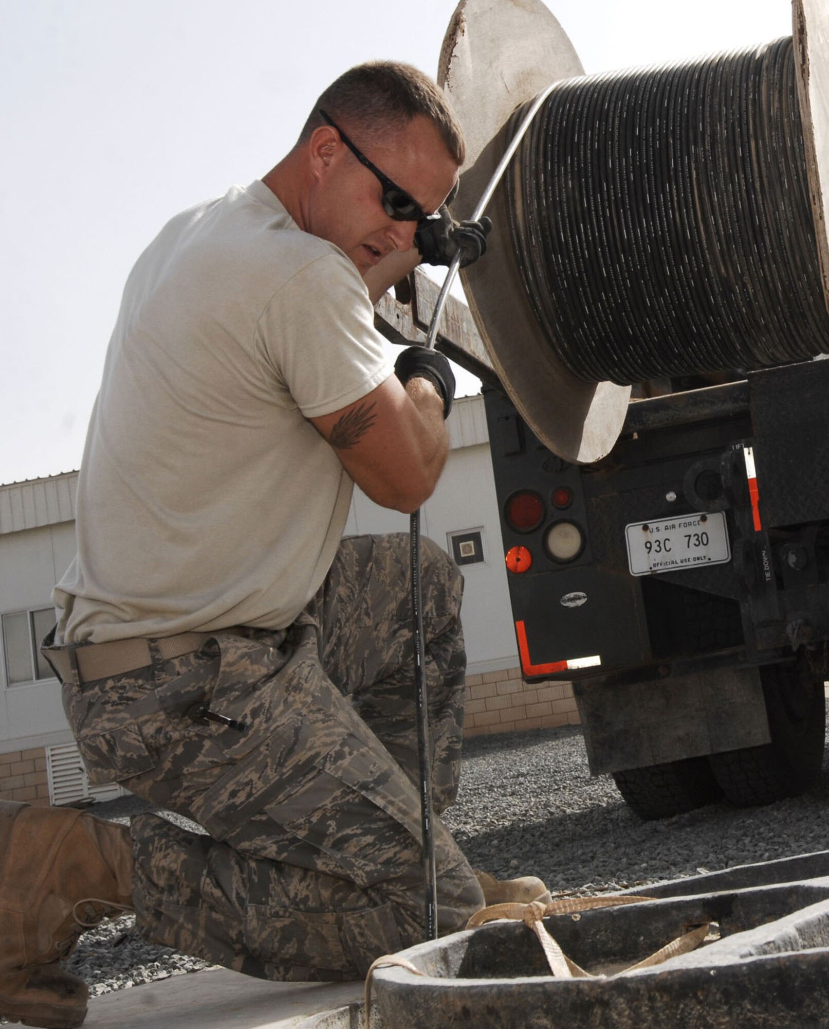 Above, Sergeant Billings feeds cable into a manhole to Airman Nichols.  Both Airmen are cable communication and antenna maintenance specialists. Installation of the new cable provides worldwide communication access to living quarters on the base.  (U.S. Air Force photo by Staff Sgt. Patrick Dixon)