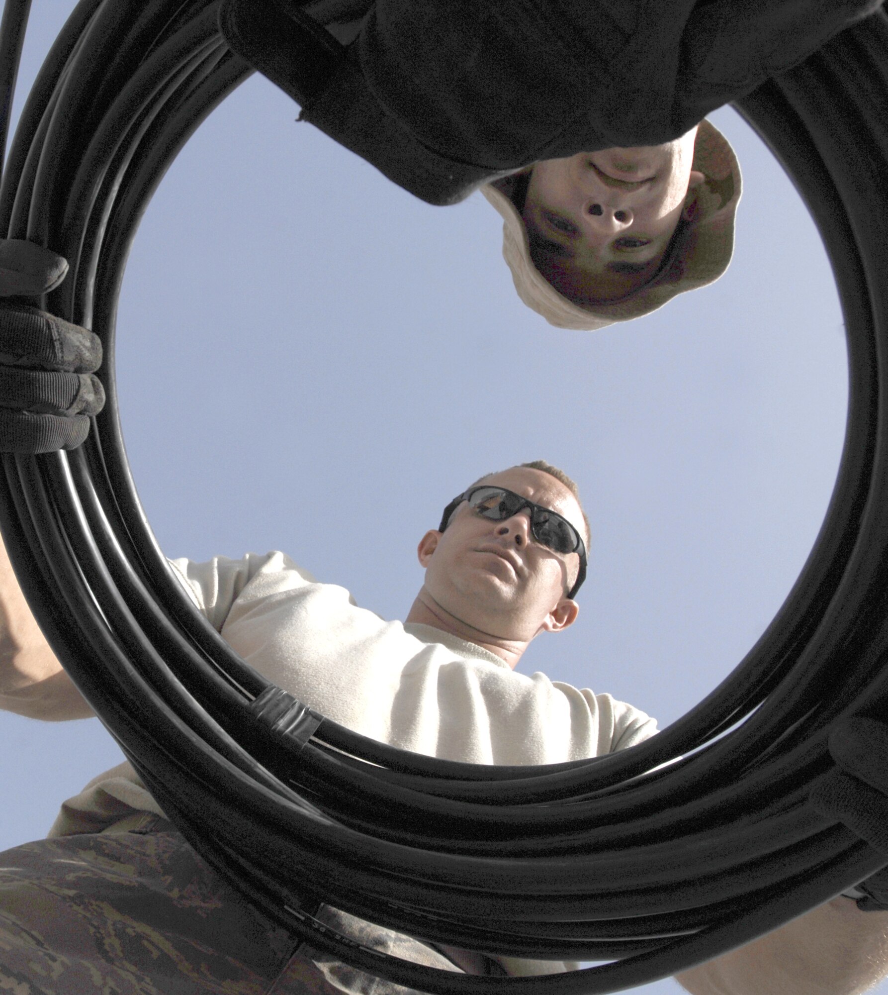 Right, Sergeant Billings and Airman Nichols wrap a bundle of cables after completing the project.  (U.S. Air Force photo by Staff Sgt. Patrick Dixon)