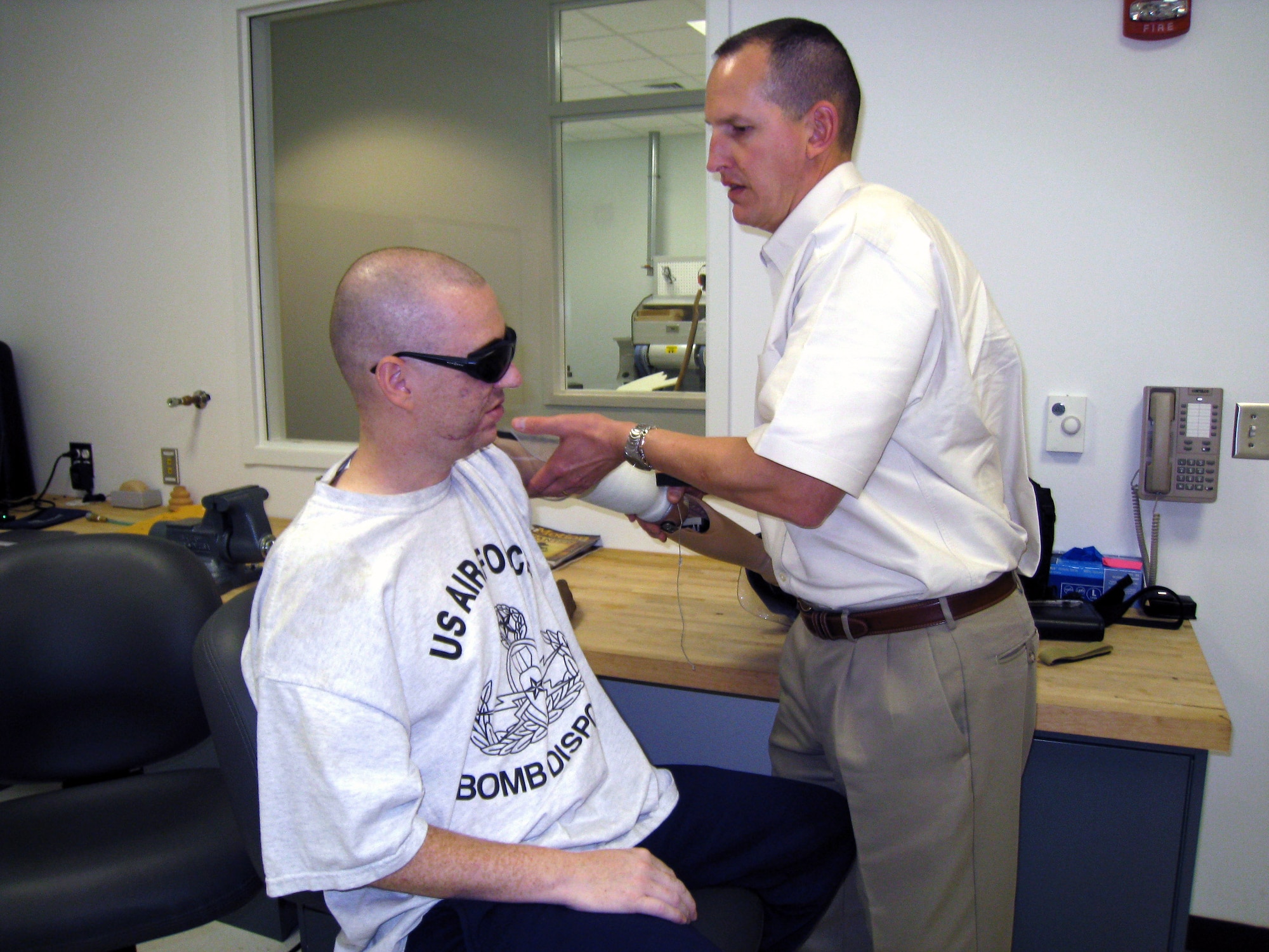 Del Lipa, a prosthetist with Brooke Army Medical Center in San Antonio, fits Staff Sgt. Matthew Slaydon with a prosthetic arm in January. Sergeant Slaydon's left arm was amputated above the elbow after a terrorist's bomb exploded while the EOD technician was trying to clear an area in Iraq Oct. 24, 2007. (Courtesy photo)