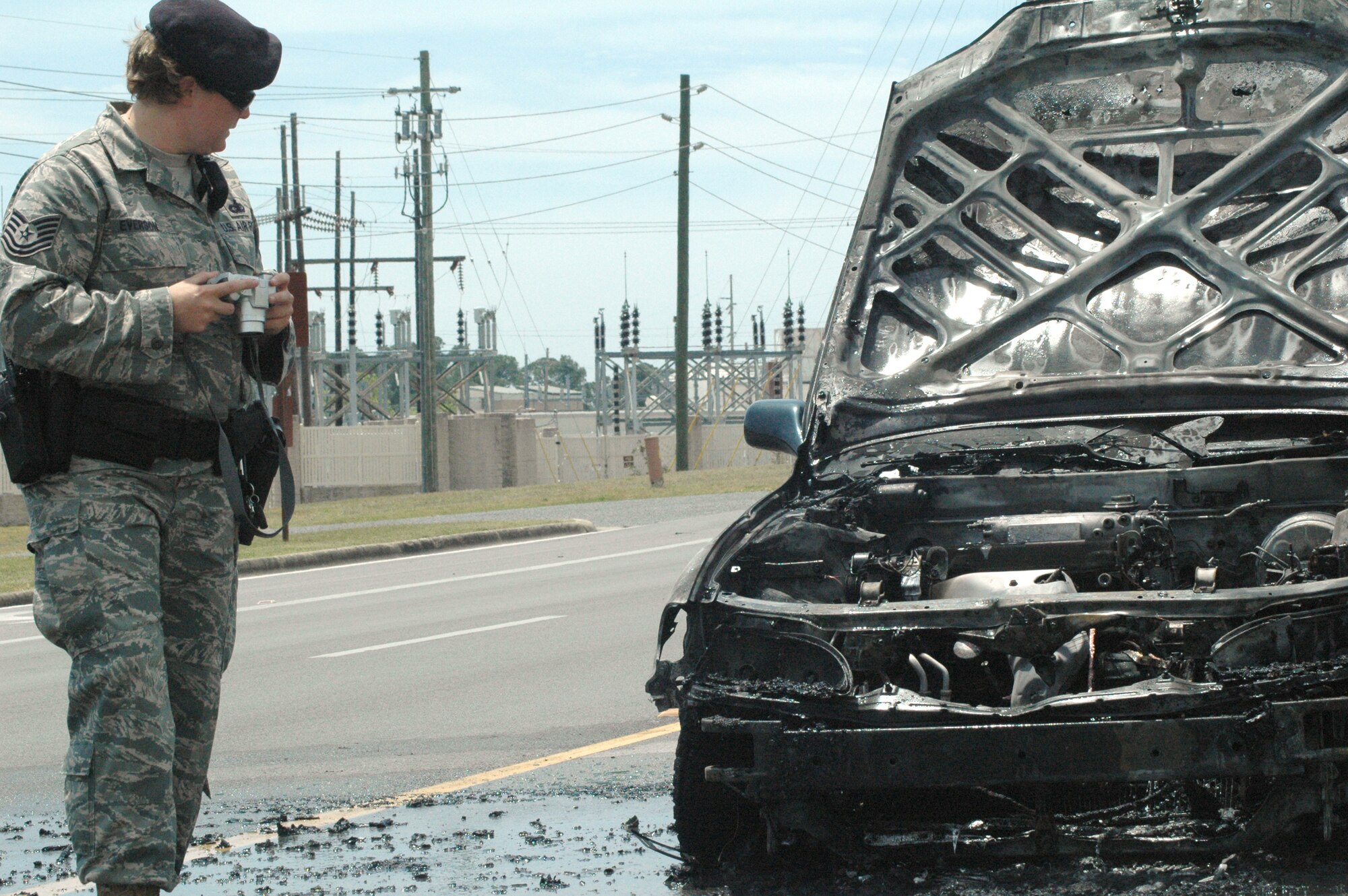 EGLIN AIR FORCE BASE, Fla. -- Tech. Sgt. Maranatha Everson, 96 Security Forces Squadron patrolman, surveys the scene of an accident on Eglin Parkway April 24 and takes photographic documentation to help preserve the scene and add to reports filed on the event. (U.S. Air Force photo/Airman 1st Class Anthony Jennings)
