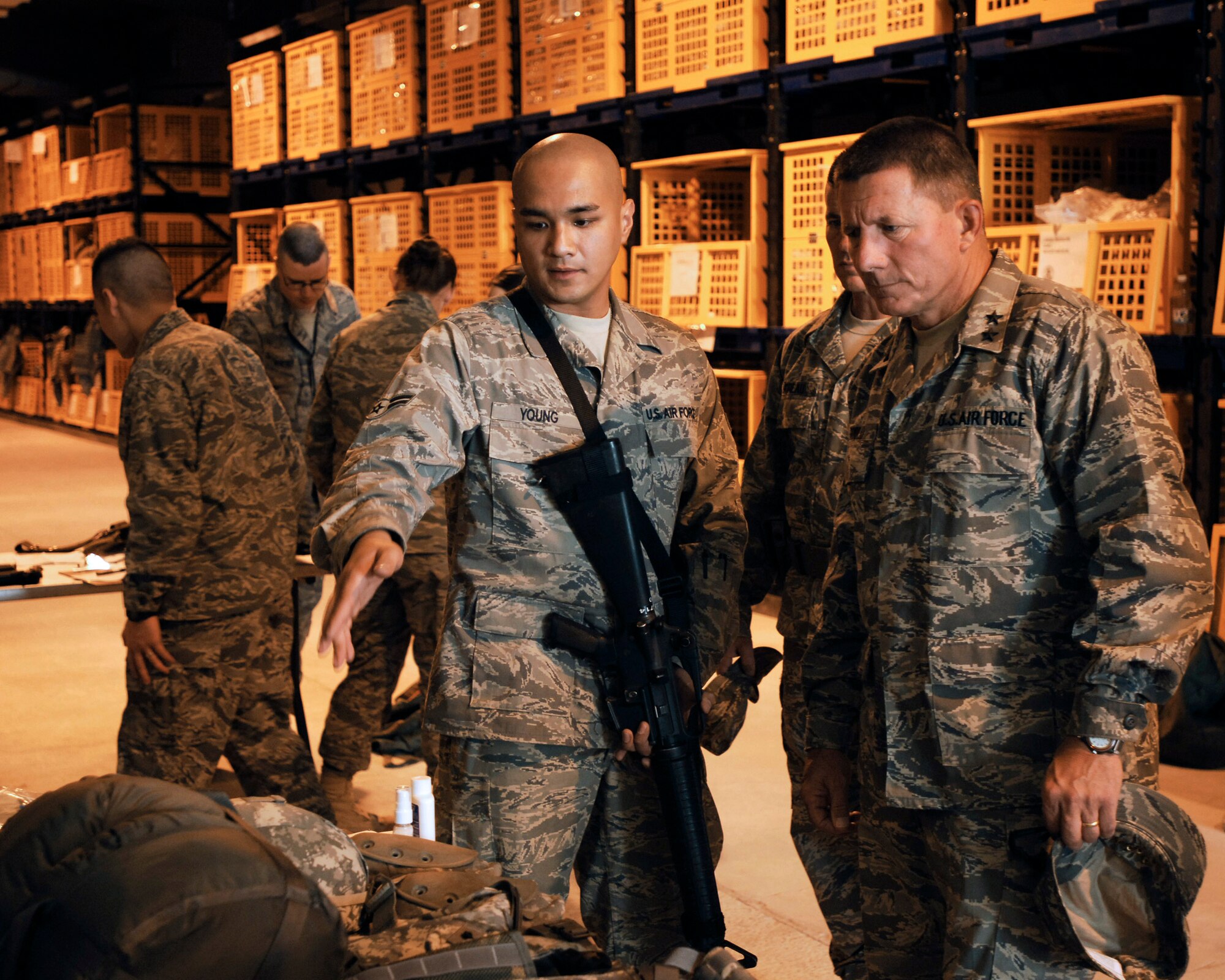Airman 1st Class Martin Young shows Maj. Gen. Michael Gould gear issued to him by the Army for his in-lieu-of deployment to Iraq.  Both Airman Young, assigned to Det. 3 of the 732nd Expeditionary Civil Engineer Squadron at an air base in Southwest Asia, and General Gould, 2nd Air Force commander, passed through the 386th Expeditionary Logistics Readiness Squadron's expeditionary theater distribution center April 23 to pick-up required gear for the Iraq theater. Airman Young is deployed from the 375th Civil Engineer Squadron, Scott Air Force Base, Ill. (U.S. Air Force photo/Staff Sgt. Patrick Dixon)