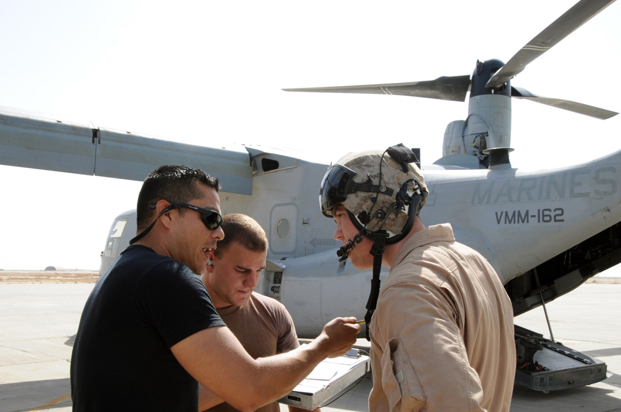 ALI BASE, Iraq -- Tech. Sgt. Frank Berrones and Senior Airman Matthew Lawson, 407th Expeditionary Logistics Readiness Squadron refueling unit operators, explain to Marine Sgt. Tim Greer, of the Marine Medium Tiltrotor Squadron 162 (VMM-162), procedures for refueling the V-22 Osprey here April 24.  The Petroleum, Oil and Lubricants section refuels various cargo aircraft from around the Area of Responsibility. Sergeant Berrones is deployed from Spangdahlem AB, Germany and Airman Lawson is deployed from Ramstein Air Base, Germany.