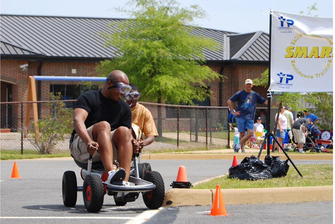 LANGLEY AIR FORCE BASE, Va. -- Mr. Roland Taylor, 1st Force Support Squadron family member program chief, takes the lead while wearing impairment goggles at KidsFest here April 19. The race track was part of the Skills Mastery and Resistance Training, or SMART Moves prevention and education program, which addresses problems such as drug and alcohol use. More than 800 children and adults attended this year's Kidfest, an annual celetration honoring military children and their families with games, prizes, food and entertainment. (U.S. Air Force photo/Staff Sgt. Misty D. Slater)