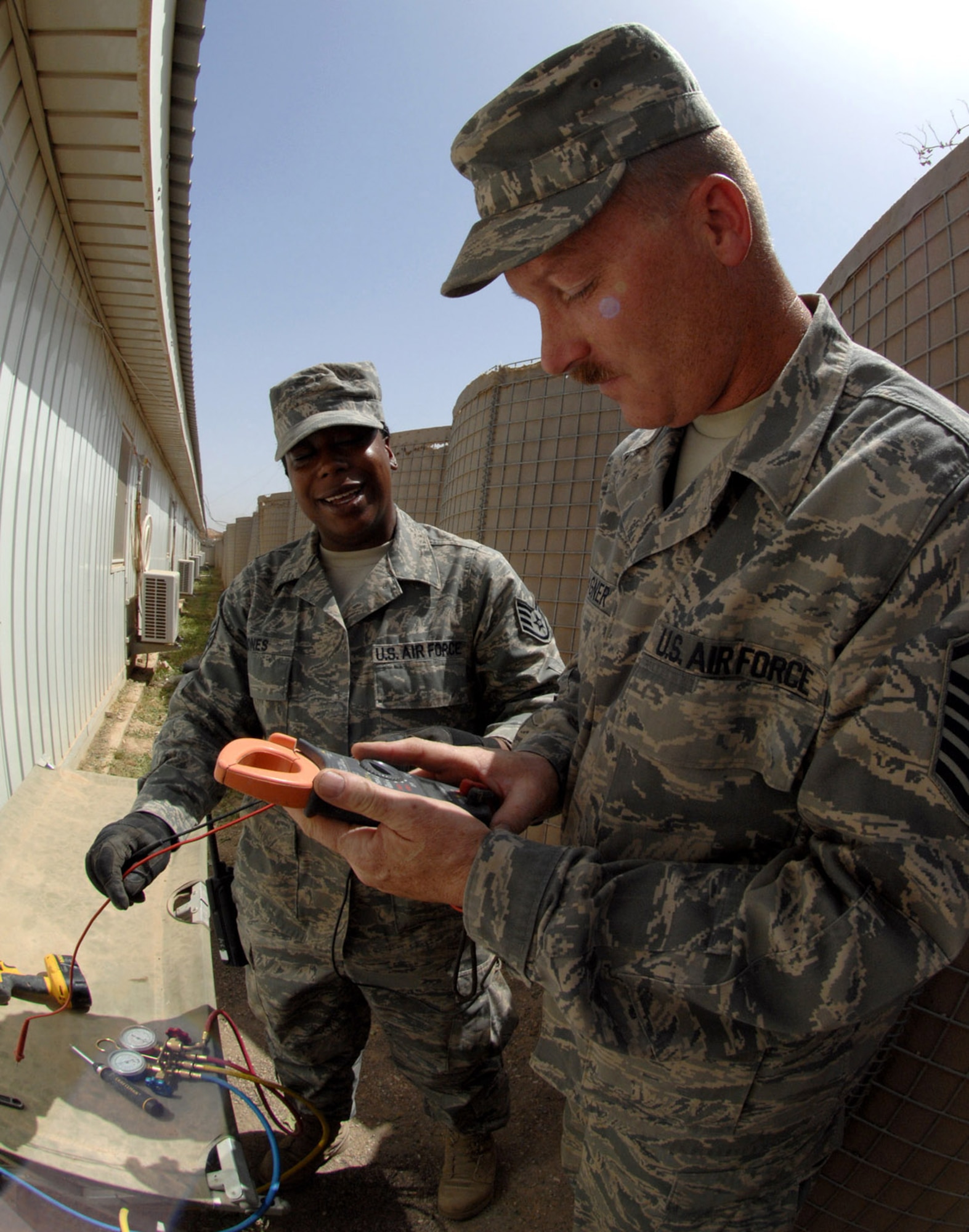 KIRKUK REGIONAL AIR BASE, Iraq – Staff Sgt. Terrica Jones and Master Sgt. Scott Wagner, 506th Expeditionary Civil Engineer Squadron, respond to a service call due to complications with an air conditioning unit April 23 here. Sergeant Wagner is deployed here from Beale Air Force Base, Calif., and is a native of Reno, Nev. Sergeant Jones is deployed here from Seymour Johnson AFB, N.C., and is a native of Fayetteville, N.C. (U.S. Air Force photo by Senior Airman SerMae Lampkin)
