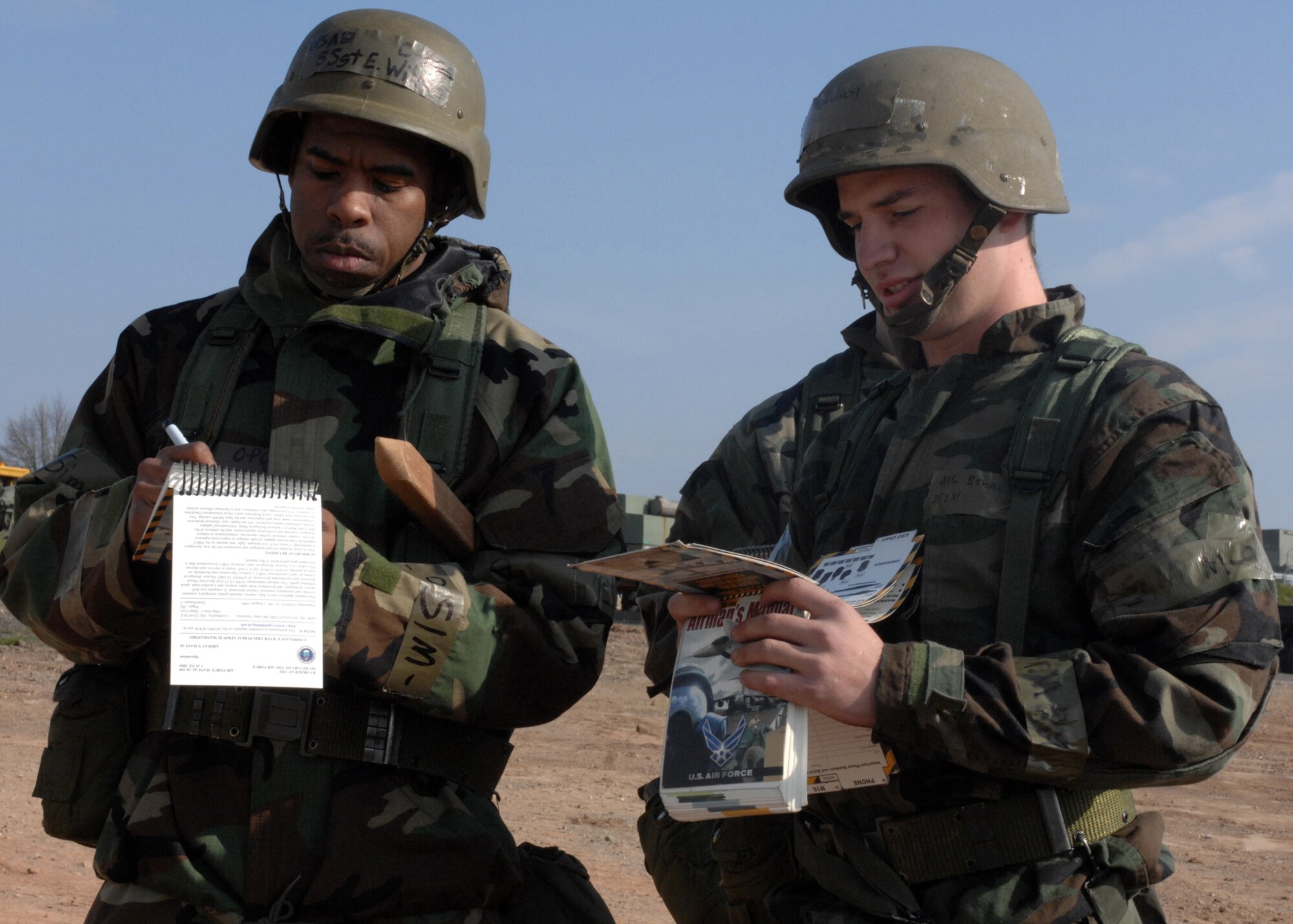 SPANGDAHLEM AIR BASE, Germany -- Staff Sgt Lester Wilson and Airman 1st Class James Bennet, both from the 52nd Civil Engineer Squadron, refer to their AFMAN 10-100 Airman’s Manual at the Ability to Survive and Operate Rodeo during the base wide exercise Operation Saber Crown 08-06 April 23, 2008. Participants in this exercise had to locate and identify various types of unexploded ordnances as well display all safety and alert precautions. (U.S. Air Force photo/ Airman 1st Class Jenifer Calhoun)