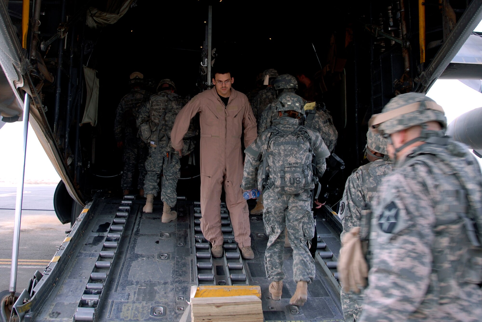 SOUTHWEST ASIA -- Airman 1st Class Armando Baez, a C-130 Hercules loadmaster deployed to the 737th Expeditionary Airlift Squadron, guides Soldiers onto the aircraft in preparation for the combat sortie that transported the Soldiers into Iraq April 21, 2008, from an air base in the Persian Gulf Region. The Air Force recently surpassed more than one million sorties flown by Air Force aircraft in the Global War on Terror since Sept. 11, 2001. Synchronized and integrated into larger coalition air efforts, these missions represent the most deliberate, disciplined and precise air campaign in history. Airman Baez is deployed from the 39th Airlift Squadron, Dyess Air Force Base, Texas. (U.S. Air Force photo/ Staff Sgt. Patrick Dixon)