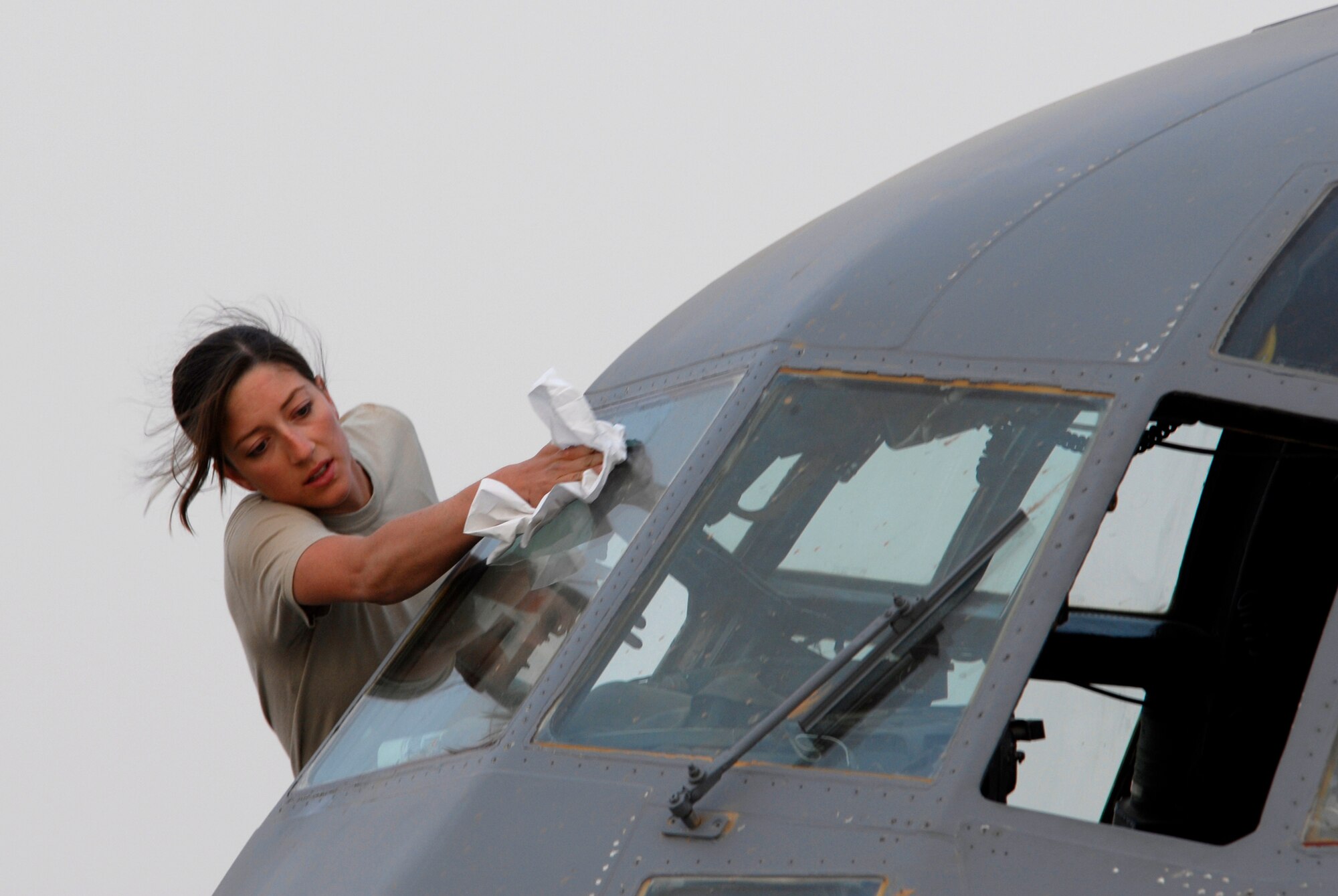SOUTHWEST ASIA -- Senior Airman Maura Dennehy, a crew chief deployed to the 386th Expeditionary Aircraft Maintenance Squadron, washes the windows of a C-130 Hercules prior to the take-off of a combat sortie that transported Soldiers into Iraq April 21, 2008, from an air base in the Persian Gulf Region. The Air Force recently surpassed more than one million sorties flown by Air Force aircraft in the Global War on Terror since Sept. 11, 2001. Synchronized and integrated into larger coalition air efforts, these missions represent the most deliberate, disciplined and precise air campaign in history. Airman Dennehy is deployed from the 317th Maintenance Squadron, Dyess Air Force Base, Texas. (U.S. Air Force photo/ Staff Sgt. Patrick Dixon)