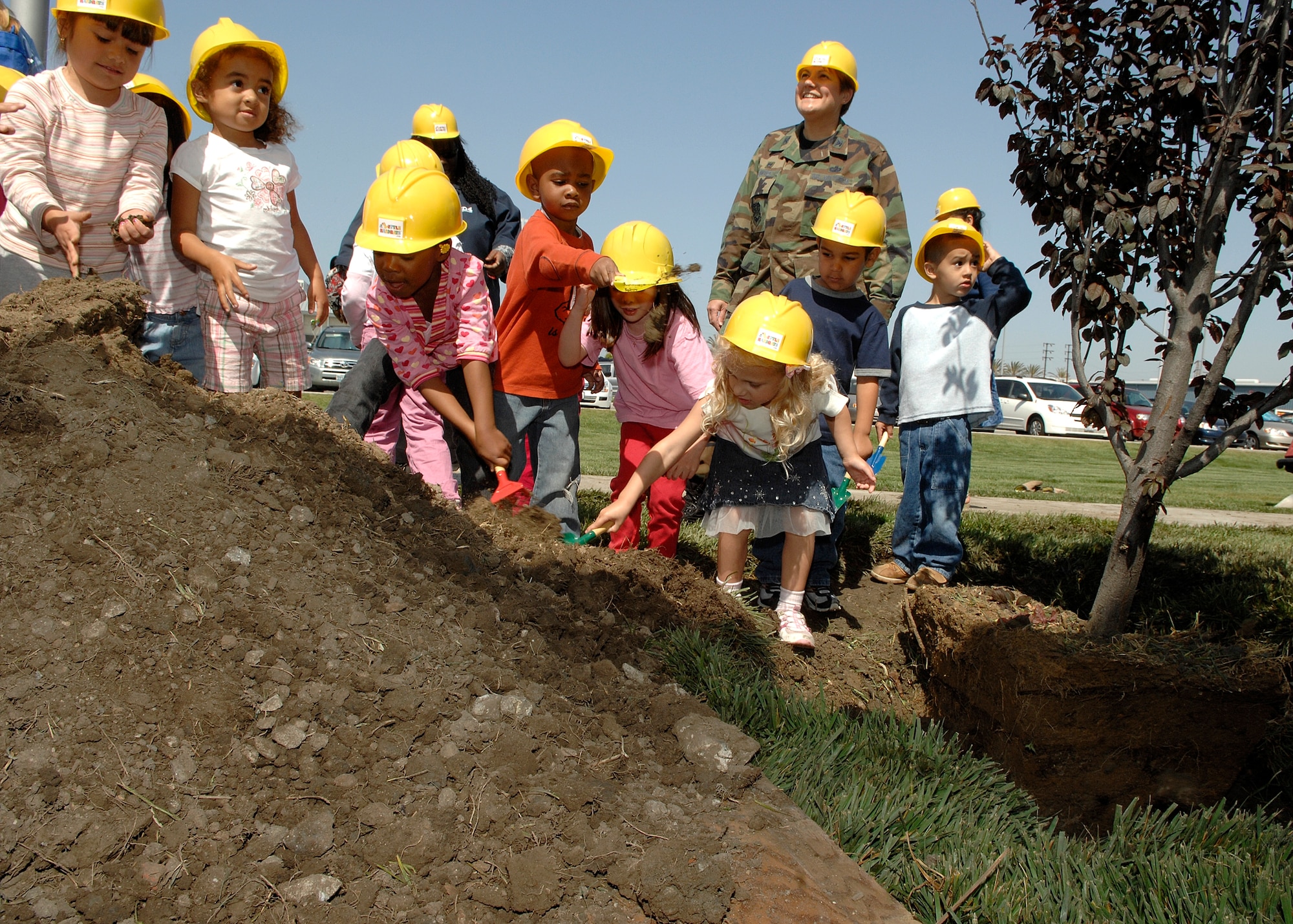 Col. Nannette Benitez, 61st Mission Support Group commander, joins children from the CDC to plant a tree for Earth Day.  In addition to the tree planting, the 61st Civil Engineering and Logistics Squadron sponsored an Earth Day Fair in the Schriever Courtyard, April 24. (Photo by Stephen Schester)