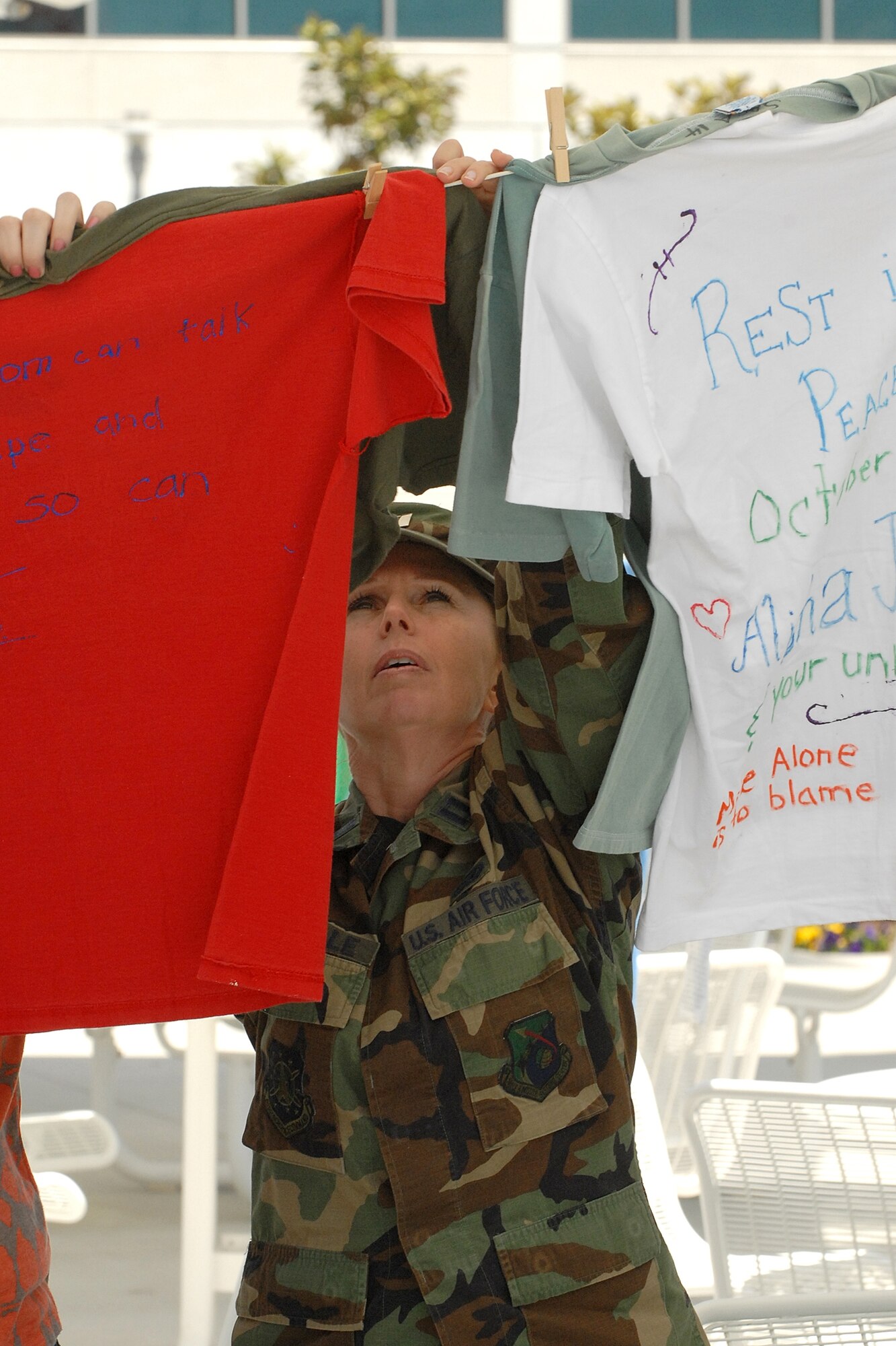 Capt. Sherry Souriolle, Los Angeles AFB SAPR office, views the Long Beach Sexual Assault Crisis Agency’s "Clothes-line Project," at the base’s Sexual Assault Outreach Fair, April 23. The display features messages written on t-shirts by women who have been assaulted.  (Photo by Stephen Schester) 