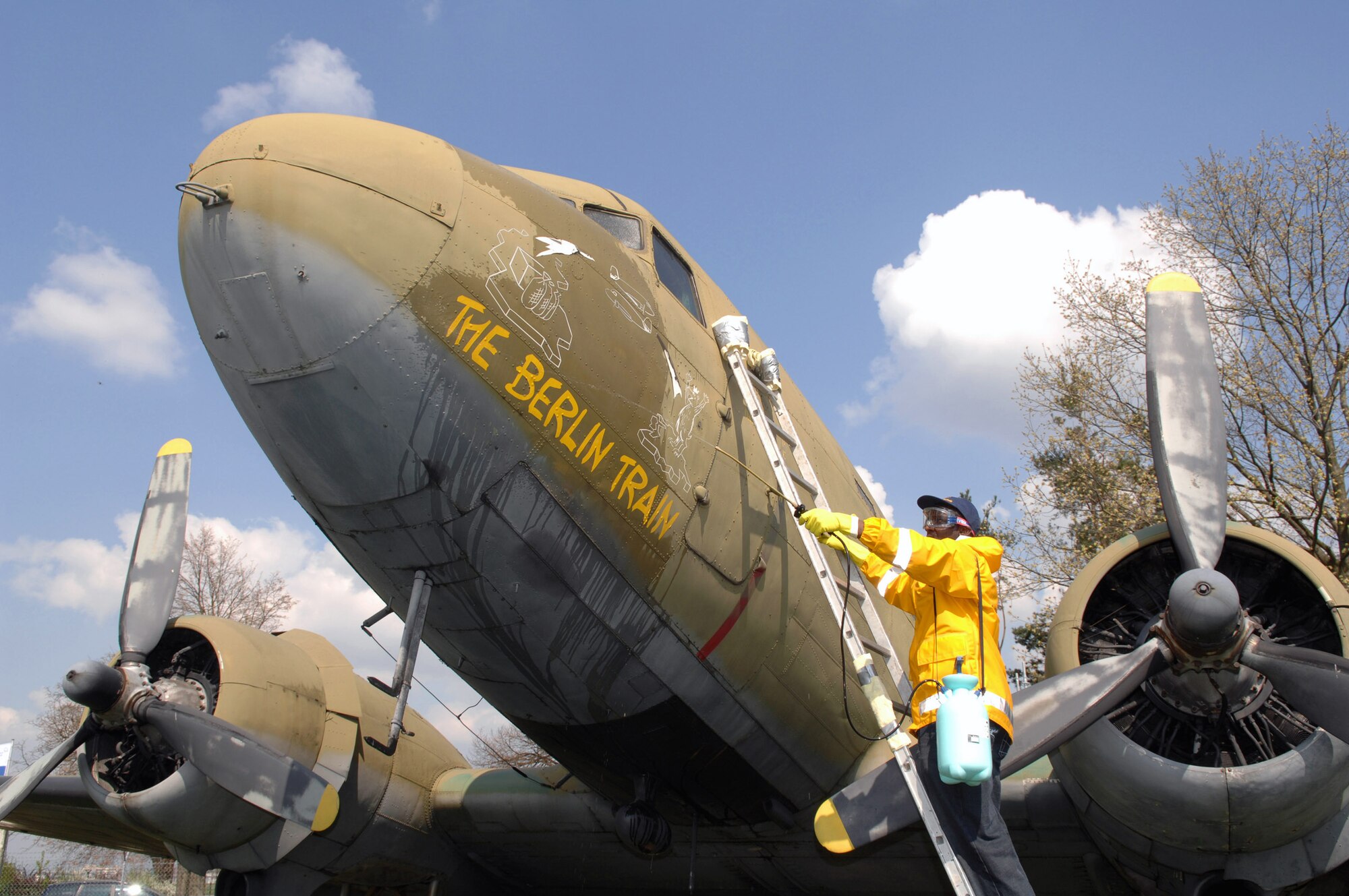 Staff Sgt. Federico Hudson cleans the nose art on a static C-54 aircraft on display at the Berlin Airlift Memorial site at the former Rhein Main Air Base near Frankfurt International Airport in Germany. Sergeant Hudson and a team of approximately 30 volunteers from Ramstein AB spent three days cleaning the display aircraft for refurbishing in prepartion for a Berlin Airlift 60th Anniversary Celebration to take place there in June. (U.S. Air Force photo/Tech. Sgt. Corey Clements) 