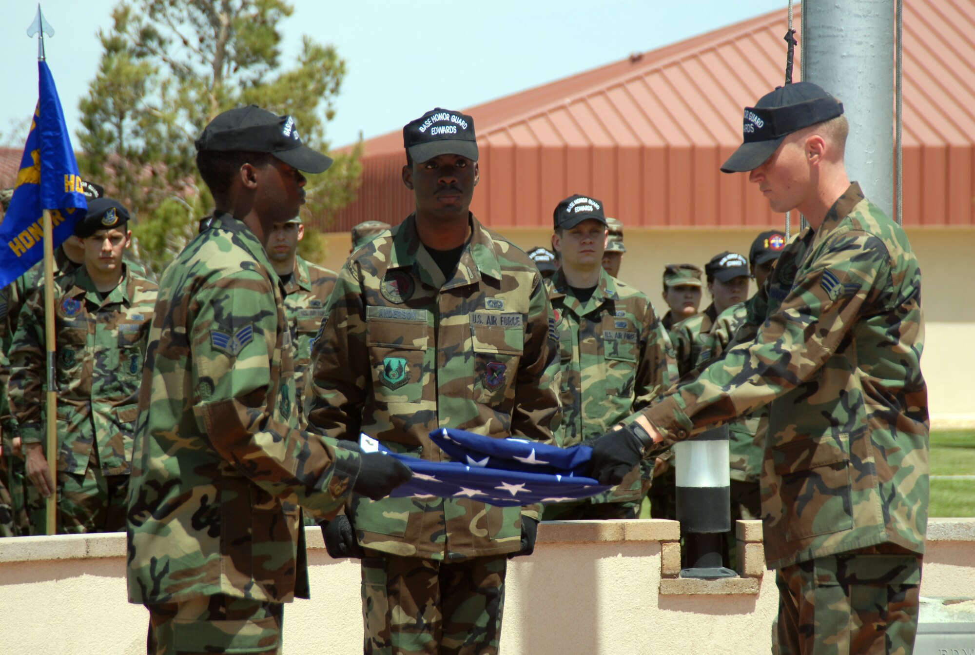 EDWARDS AIR FORCE BASE, Calif. -- Edwards Blue Eagle Honor Guard members fold an American flag during a retreat ceremony in front of the Air Force Flight Test Center here April 25.The retreat ceremony, which marked the return of monthly retreat ceremonies for Edwards, was in honor of Chief Master Sgt. Juan Lewis, 95th ABW command chief, who is moving on to be the command chief for the 37th Training Wing at Lackland Air Force Base, Texas.  (Air Force photo by Senior Airman Julius Delos Reyes)