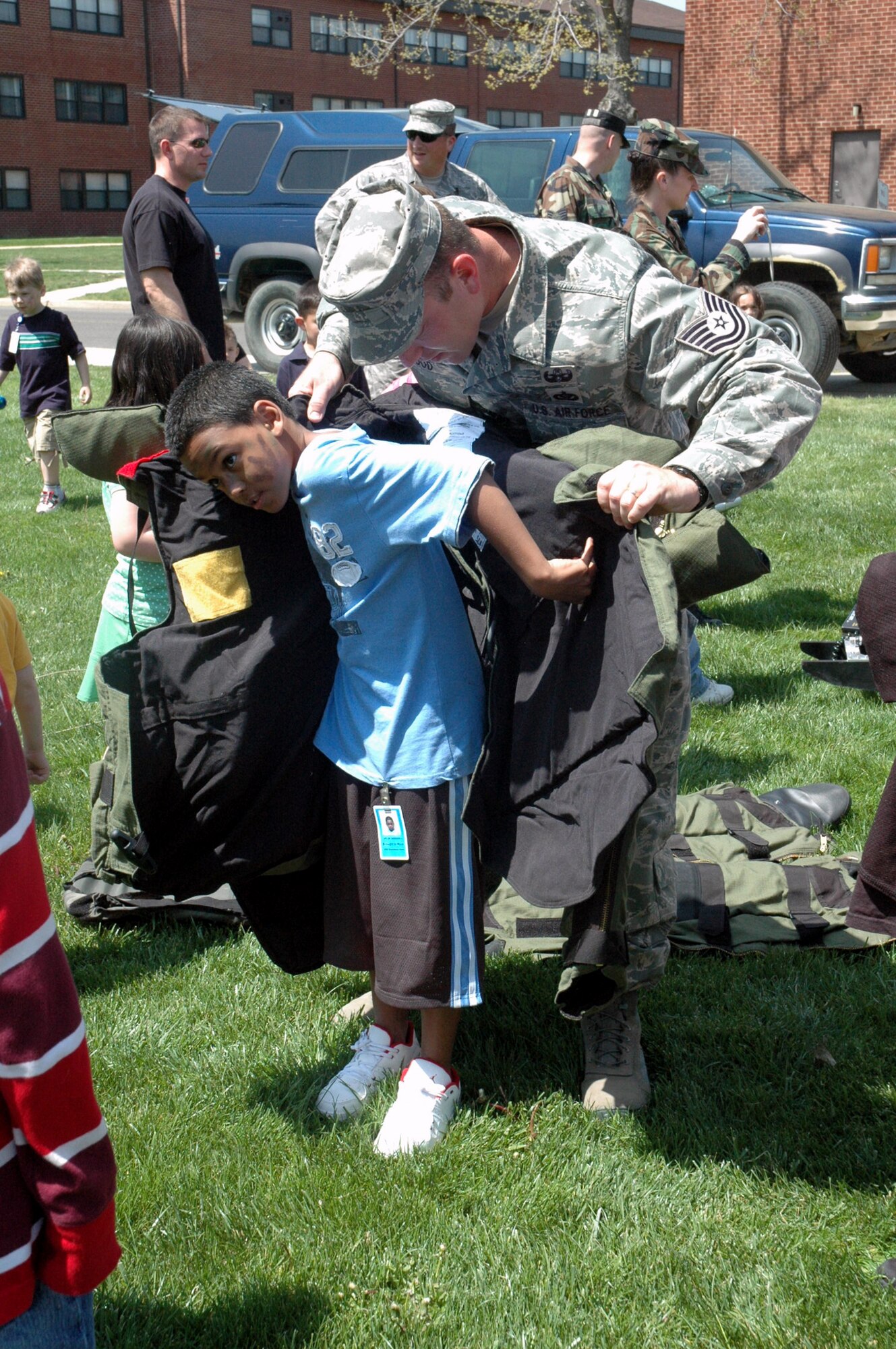 Tech. Sgt. Vandiver Hood, from the U.S. Air Force Expeditionary Center's 421st Combat Training Squadron, helps a child try on a bomb suit used by explosive ordnance disposal Airmen as part of a demonstration event for "Take Your Children to Work Day" at the Center on Fort Dix April 24, 2008.  More than 70 children participated in the event. (U.S. Air Force Photo/Tech. Sgt. Scott T. Sturkol)