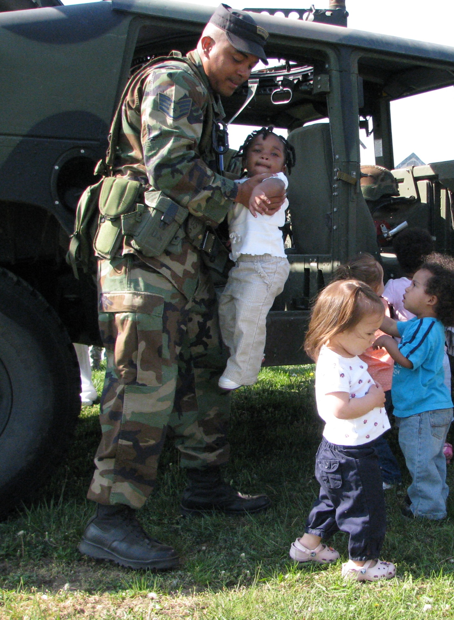 Staff Sgt. Nelson Brown, from the U.S. Air Force Expeditionary Center's 421st Combat Training Squadron at Fort Dix, N.J., helps children at the McGuire Air Force Base, N.J., child development center learn about a HMMWV as part of an tactical vehicle display event put on by the 421st April 24, 2008.  More than 150 children from the McGuire CDCs participated seeing HMMWVs and military trucks presented by numerous Airmen from the Center. (U.S. Air Force Photo/Staff Sgt. Paul Evans)