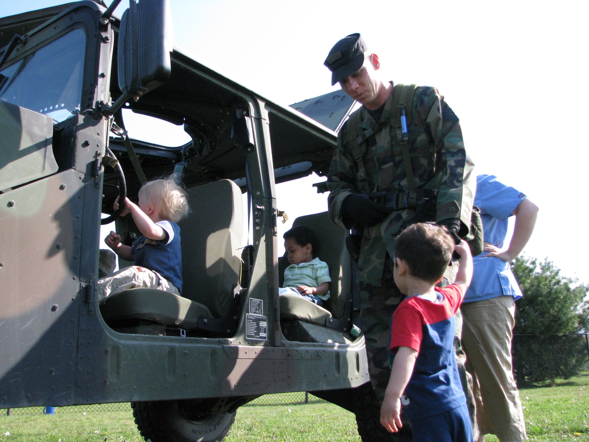 Tech. Sgt. Chad Ohr, from the U.S. Air Force Expeditionary Center's 421st Combat Training Squadron at Fort Dix, N.J., helps children at the McGuire Air Force Base, N.J., child development center learn about a HMMWV as part of an tactical vehicle display event put on by the 421st April 24, 2008.  More than 150 children from the McGuire CDCs participated seeing HMMWVs and military trucks presented by numerous Airmen from the Center. (U.S. Air Force Photo/Staff Sgt. Paul Evans)
