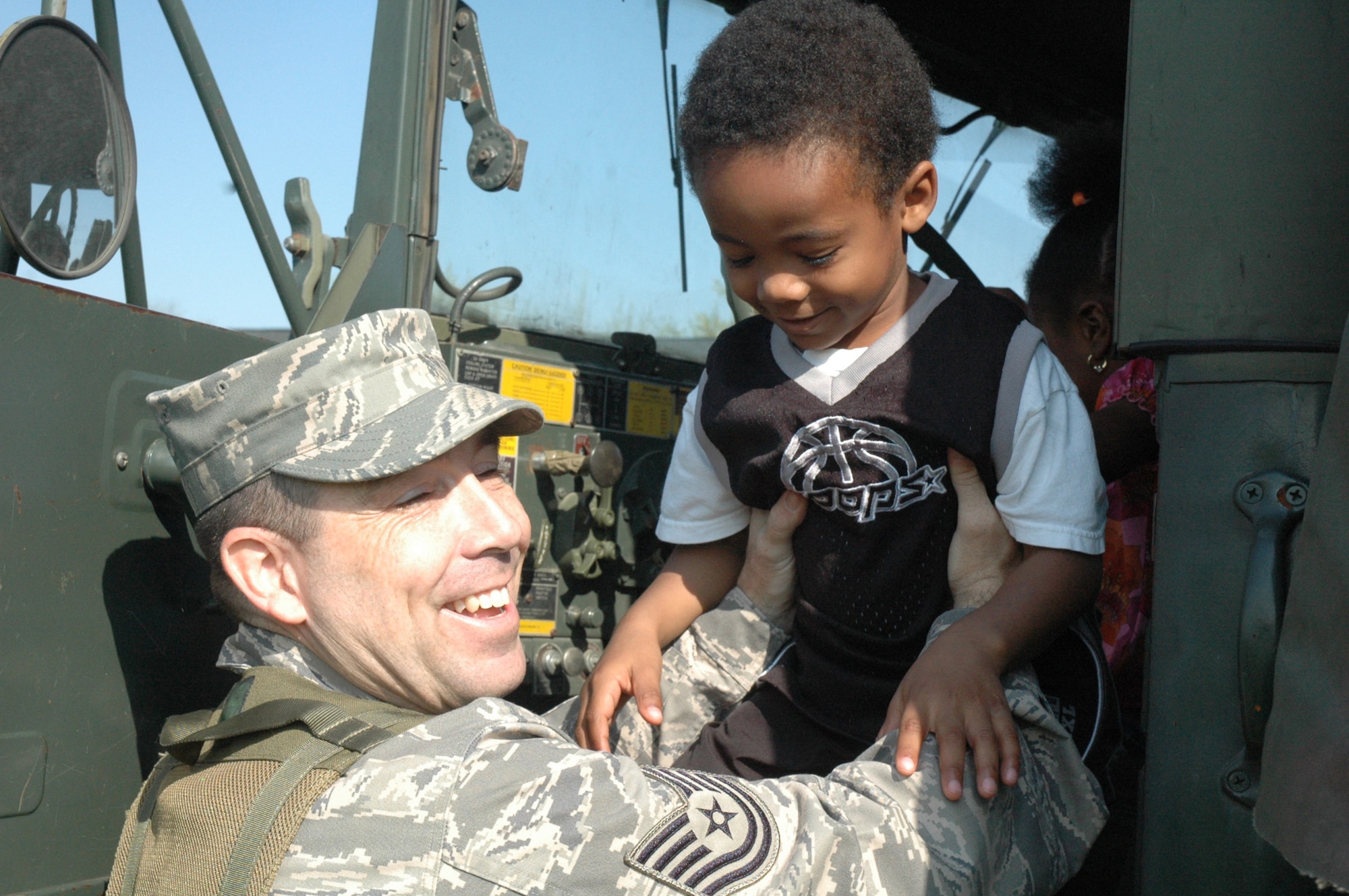 Tech. Sgt. Roy Johnson, fom the U.S. Air Force Expeditionary Center's 421st Combat Training Squadron at Fort Dix, N.J., shows children at the McGuire Air Force Base, N.J., child development center the inside of a military truck April 24, 2008.  The demonstration was part of an effort by the 421st CTS who sent several Airmen to the CDCs at McGuire and Fort Dix for a tactical vehicle display and demonstration.  (U.S. Air Force Photo/Tech. Sgt. Scott T. Sturkol)