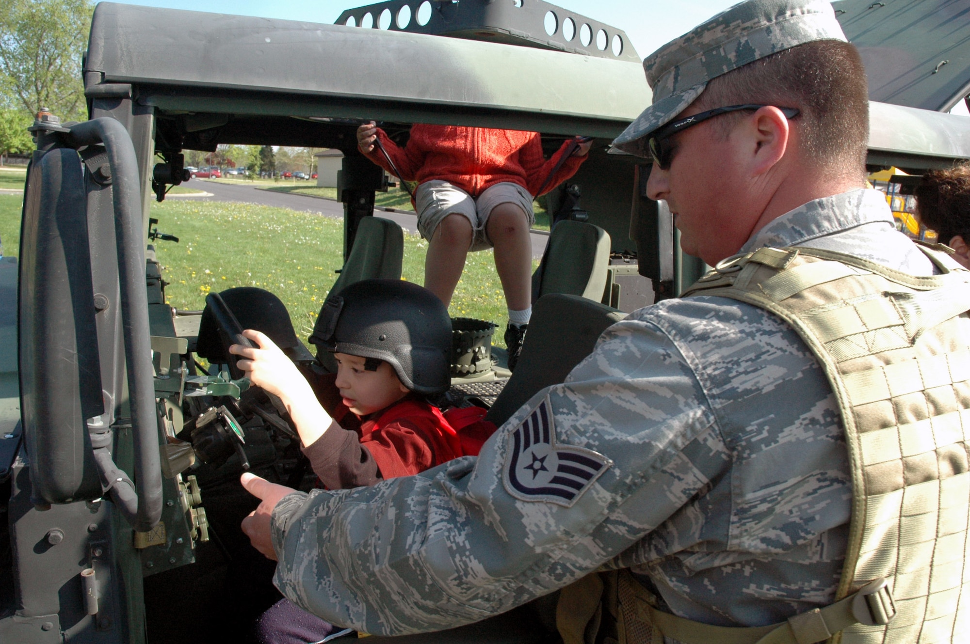 Tech. Sgt. Eric Morgan, from the U.S. Air Force Expeditionary Center's 421st Combat Training Squadron at Fort Dix, N.J., shows children at the McGuire Air Force Base, N.J., child development center how a the inside of a HMMWV April 24, 2008, at McGuire.  The demonstration was part of an effort by the 421st CTS who sent several Airmen to the CDCs at McGuire and Fort Dix for a tactical vehicle display and demonstration.  (U.S. Air Force Photo/Tech. Sgt. Scott T. Sturkol)