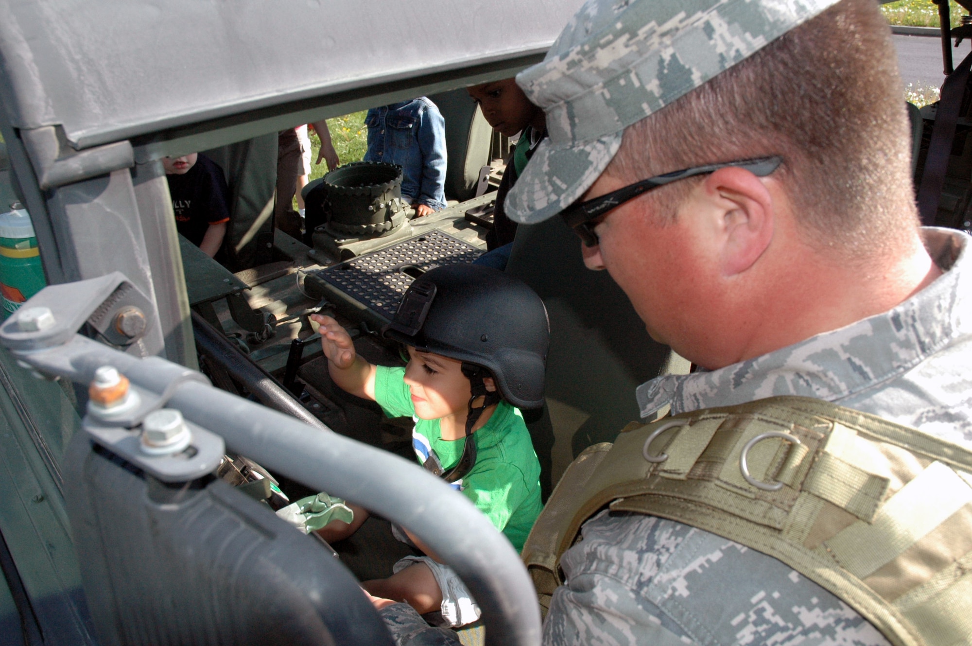 Tech. Sgt. Eric Morgan, from the U.S. Air Force Expeditionary Center's 421st Combat Training Squadron at Fort Dix, N.J., shows children at the McGuire Air Force Base, N.J., child development center how a the inside of a HMMWV April 24, 2008, at McGuire.  The demonstration was part of an effort by the 421st CTS who sent several Airmen to the CDCs at McGuire and Fort Dix for a tactical vehicle display and demonstration.  (U.S. Air Force Photo/Tech. Sgt. Scott T. Sturkol)