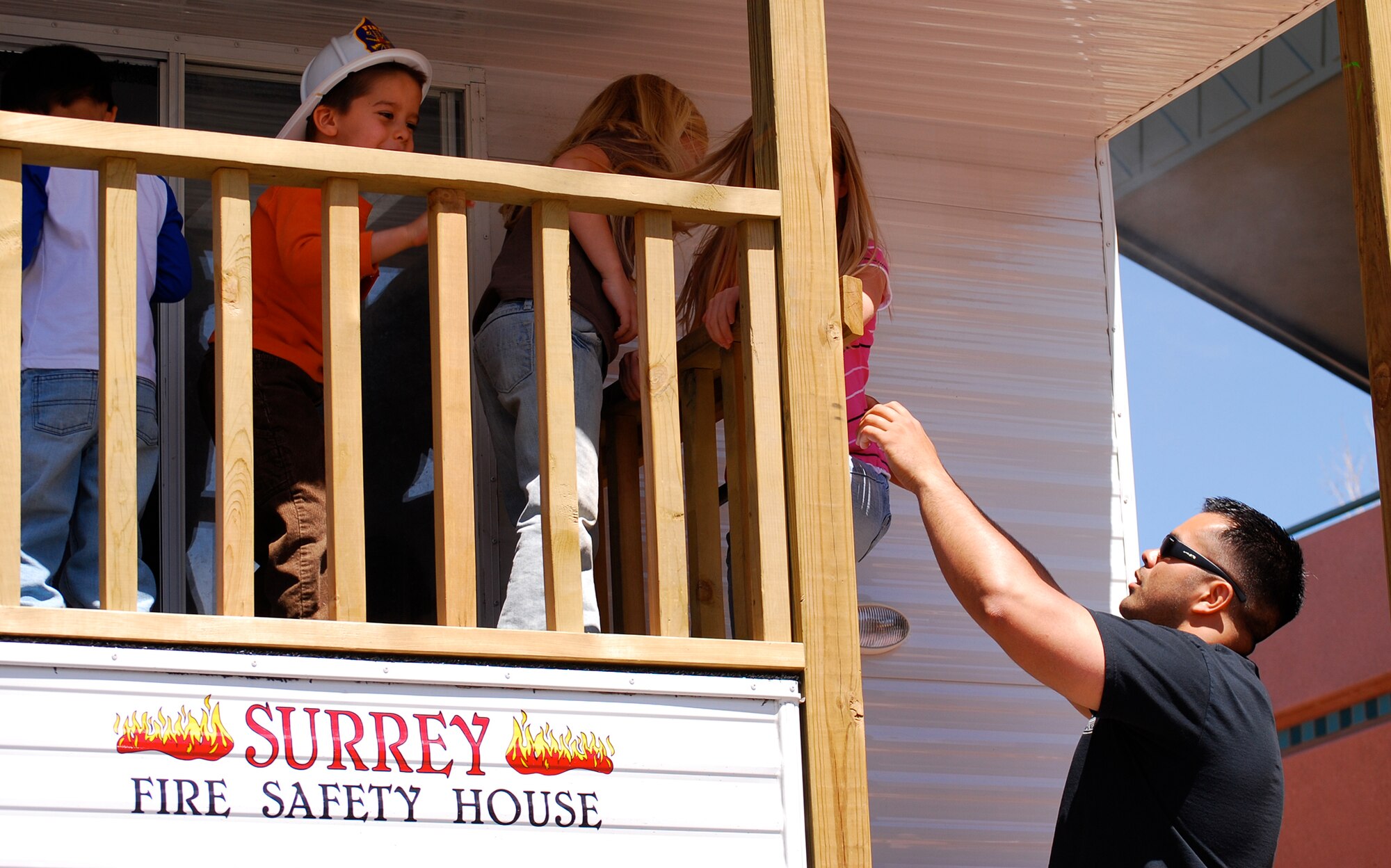 Staff Sgt. Timmi Bjorsvik of Peterson’s Fire Department helps kids climb down from the department’s safety trailer April 19 at Colorado Springs’ Earth Day event. The fire department brought the trailer to the city’s famous Garden of the Gods park for the event to teach kids about fire and weather safety. The mobile trainer simulates thunder and lightning, teaches kids what to do in case of a fire or tornado and teaches concepts such as ‘Stop, Drop and Roll.’ (U.S. Air Force photo/Burke Ferrin)  