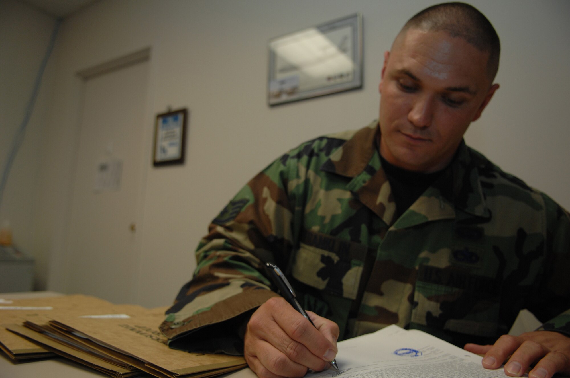 Staff Sergeant Jason Franklin, Assistant NCOIC, Installation Personnel Readiness Unit, 49th Force Support Squadron signs his signature on the NATO deployment orders for members selected to deploy Apr 22, Holloman Air Force Base, N.M. (U.S. Air Force photo/Senior Airman Anthony Nelson Jr)