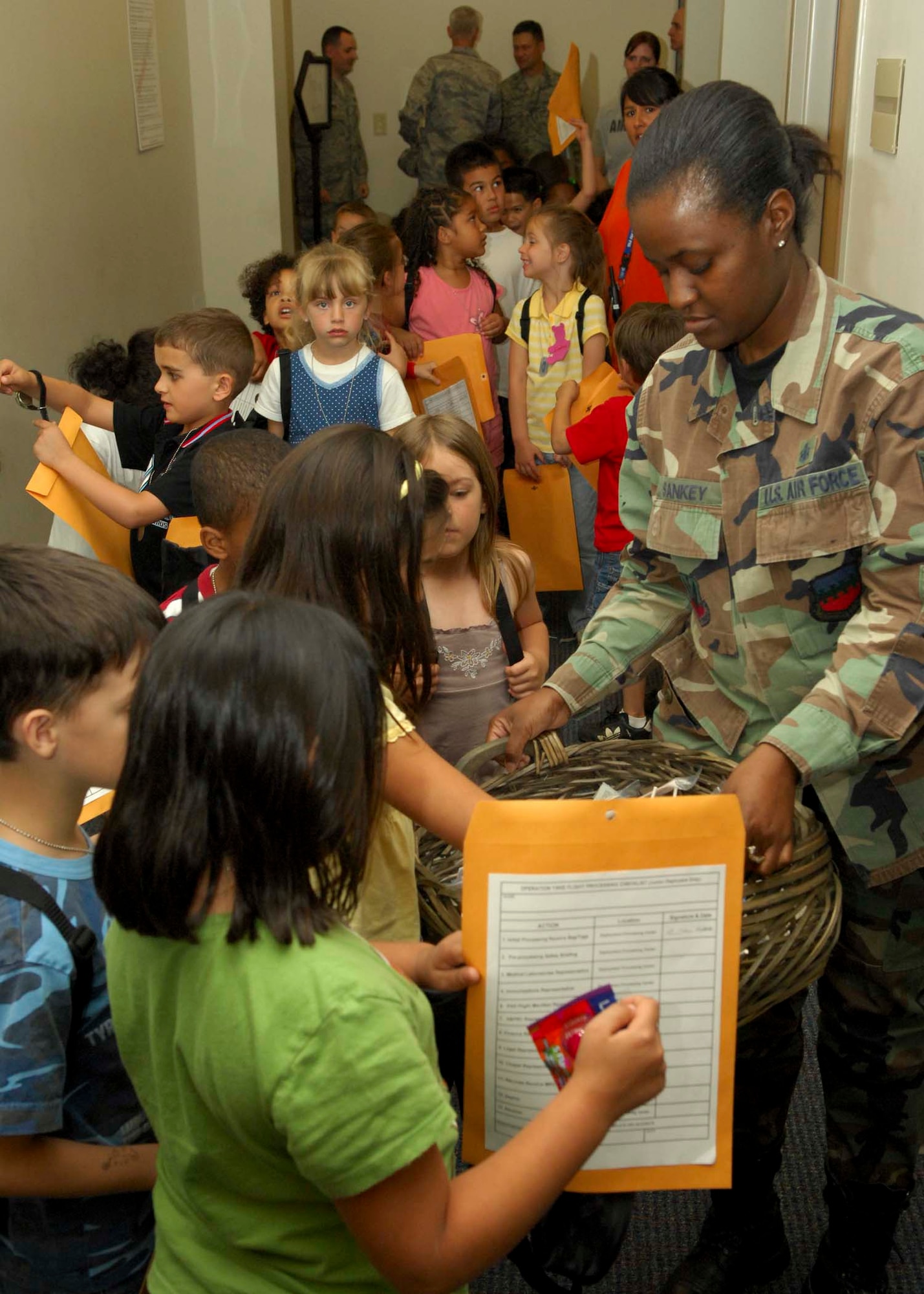 SHAW AIR FORCE BASE, S.C.-- Tech. Sgt. Tracy Sankey, 20th Medical Group immunization NCO in charge, hands out candy to junior deployers during the kids deployment processing line April 24. The kids deployment line gives children of military members a chance to experience what parents go through prior to deployment. (U.S. Air Force photo/Staff Sgt. Henry Hoegen)