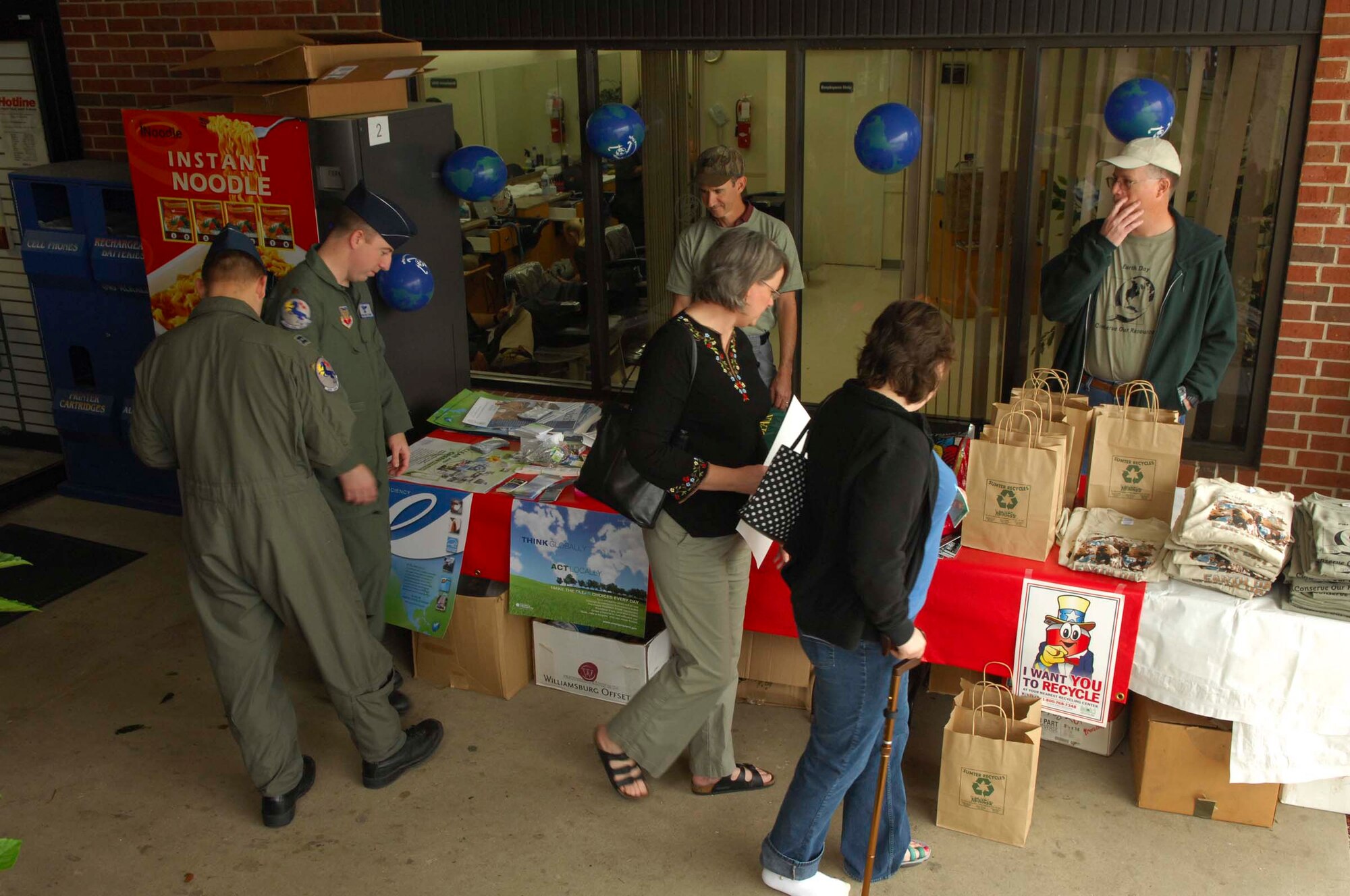 SHAW AIR FORCE BASE, S.C.-- Ronnie June and Gregg Skags, 20th Civil Engineering Squadron asset management flight, hand out free items made of recycled material to passersby in front of the Base Exchange April 22. The recycled items were being handed out to promote Earth Day. (U.S. Air Force photo/Staff Sgt. Henry Hoegen)