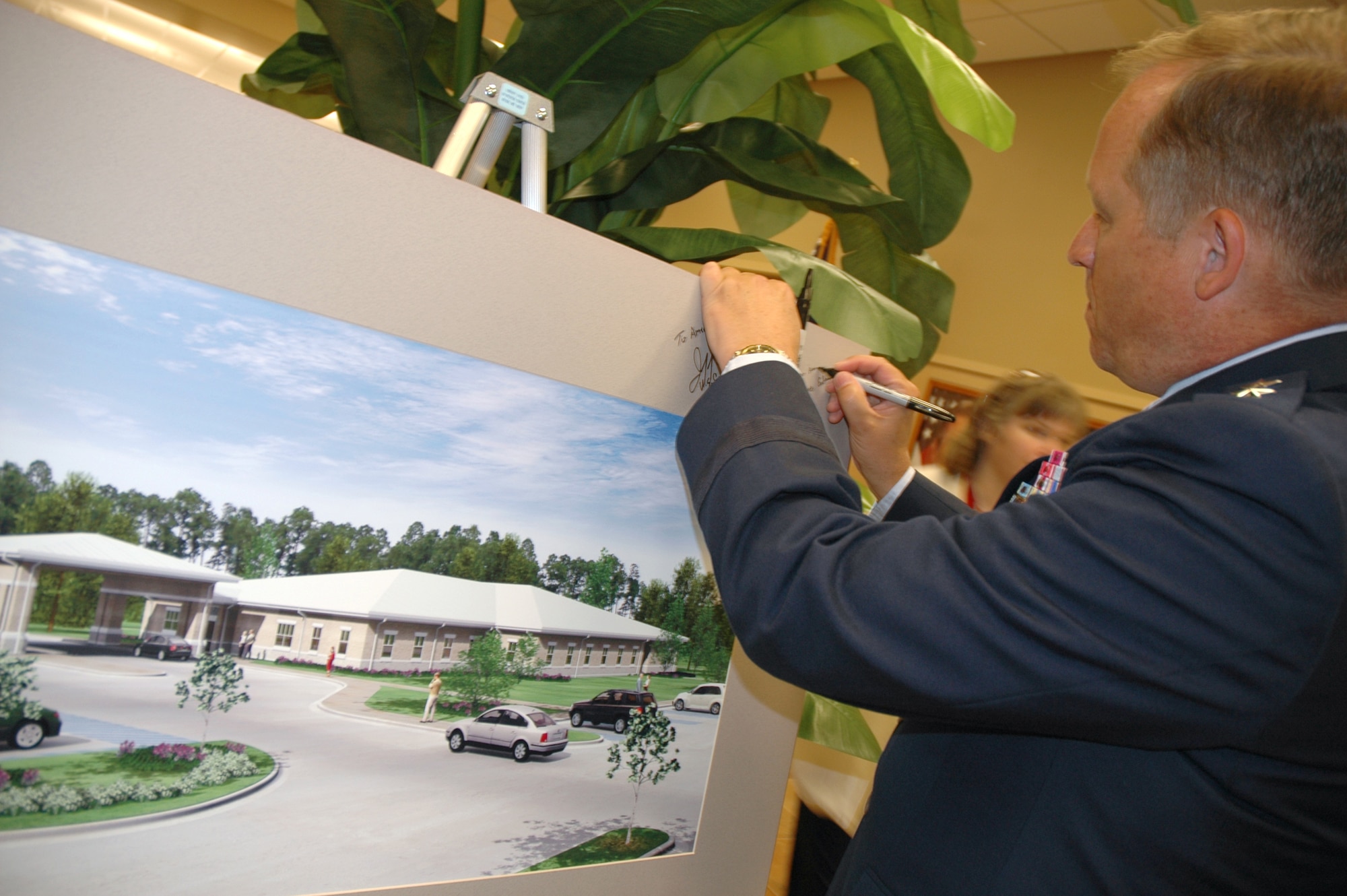 EGLIN AIR FORCE BASE, Fla. -- Maj. Gen. David W. Eidsaune, Air Force Program Executive Officer for Weapons and Air Armament Center commander, signs a matted commenorative lithograph of the artist's rendering of the new VA Clinic after the ribbon cutting ceremony April 25. (U.S. Air Force photo/Staff Sgt. Stacia Zachary)
